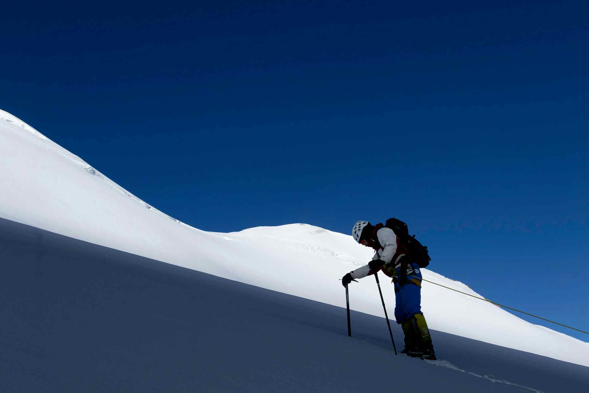 Roped climber with ice axe on snowy gradient in Ladakh, India