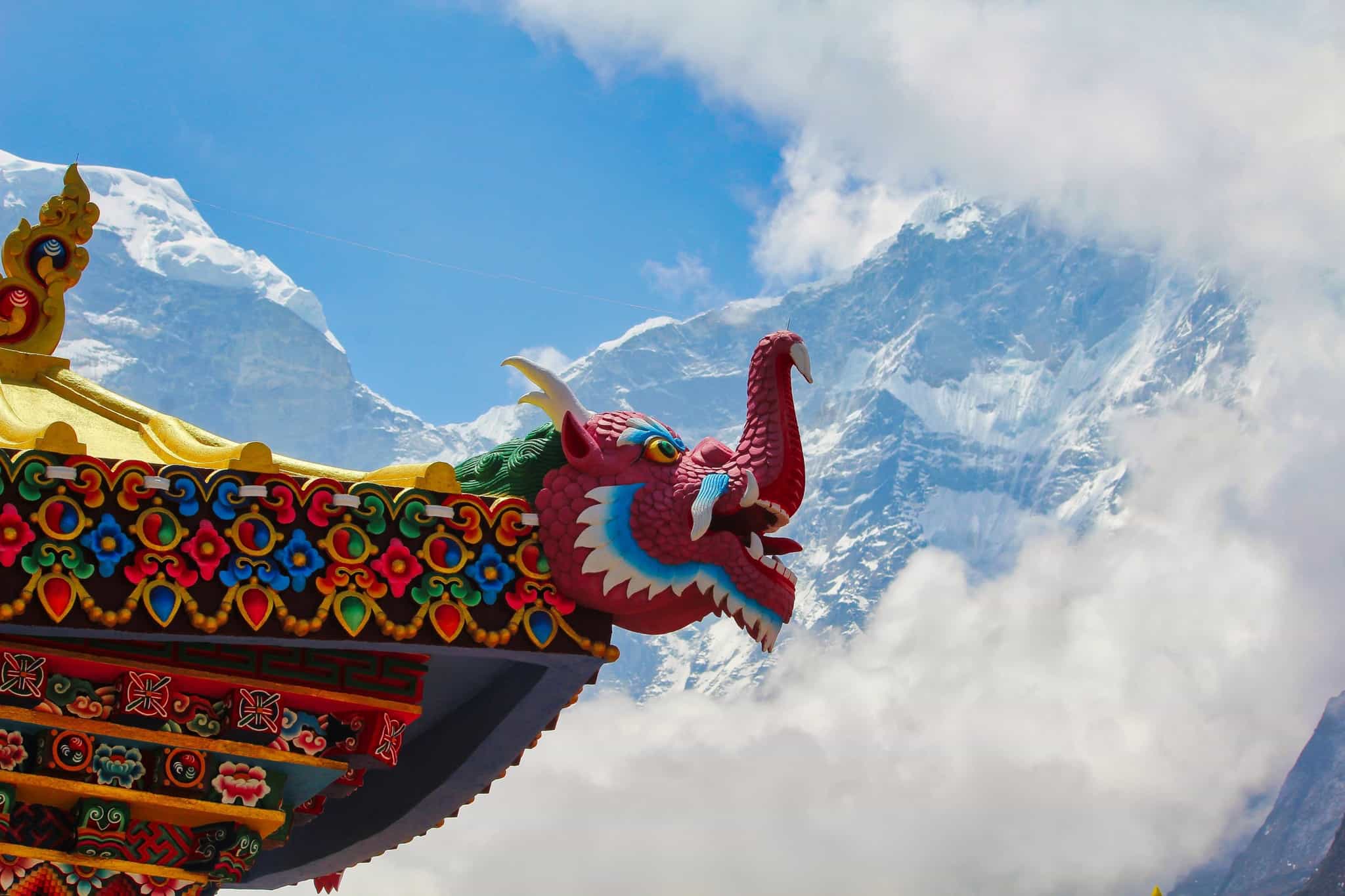 Dragon carving on Tengboche Monastery looking out at the snowy mountain peaks