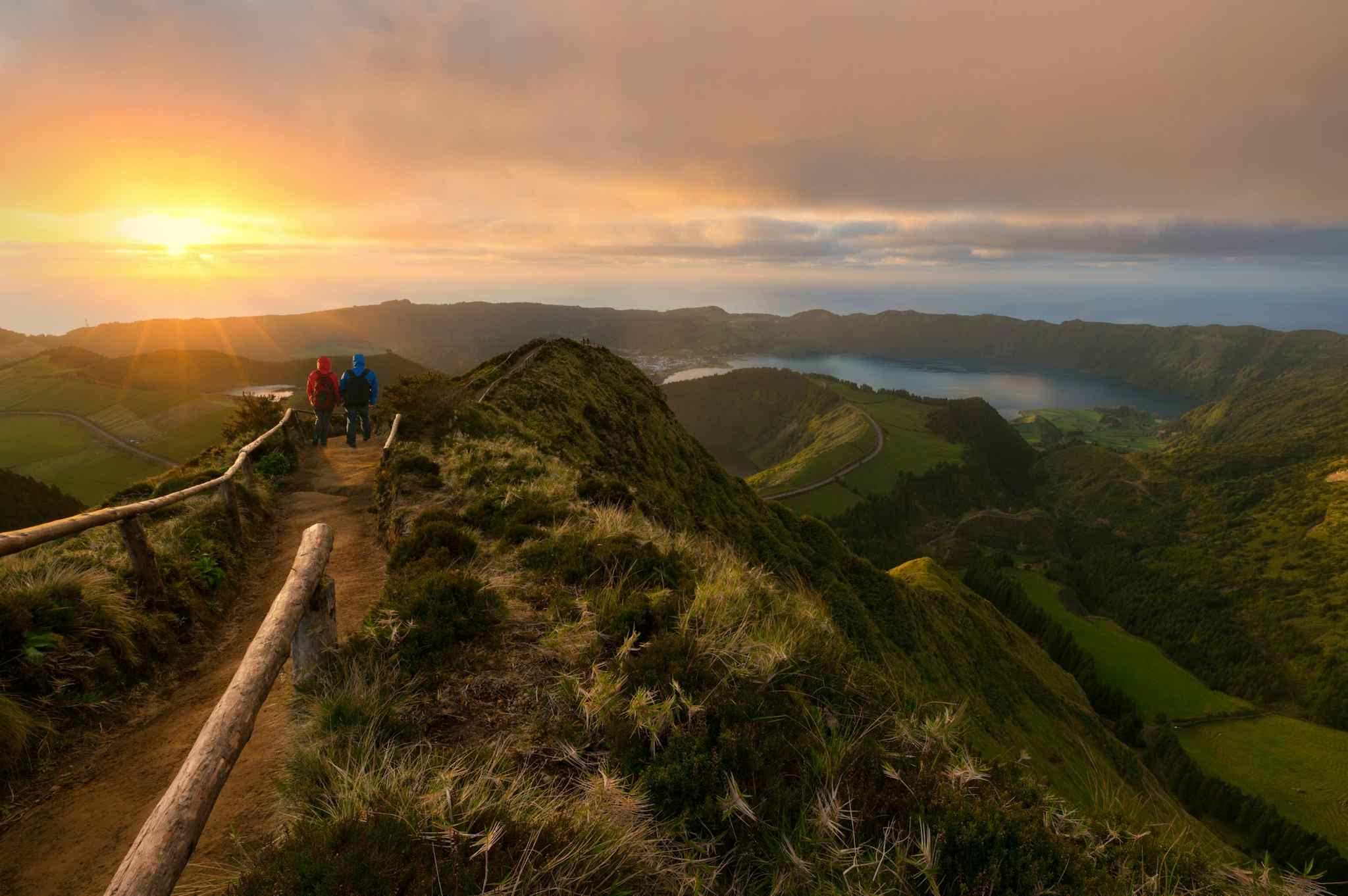 Hikers at a lookout point at sunset at Sete Cidades, Sao Miguel, Azores.