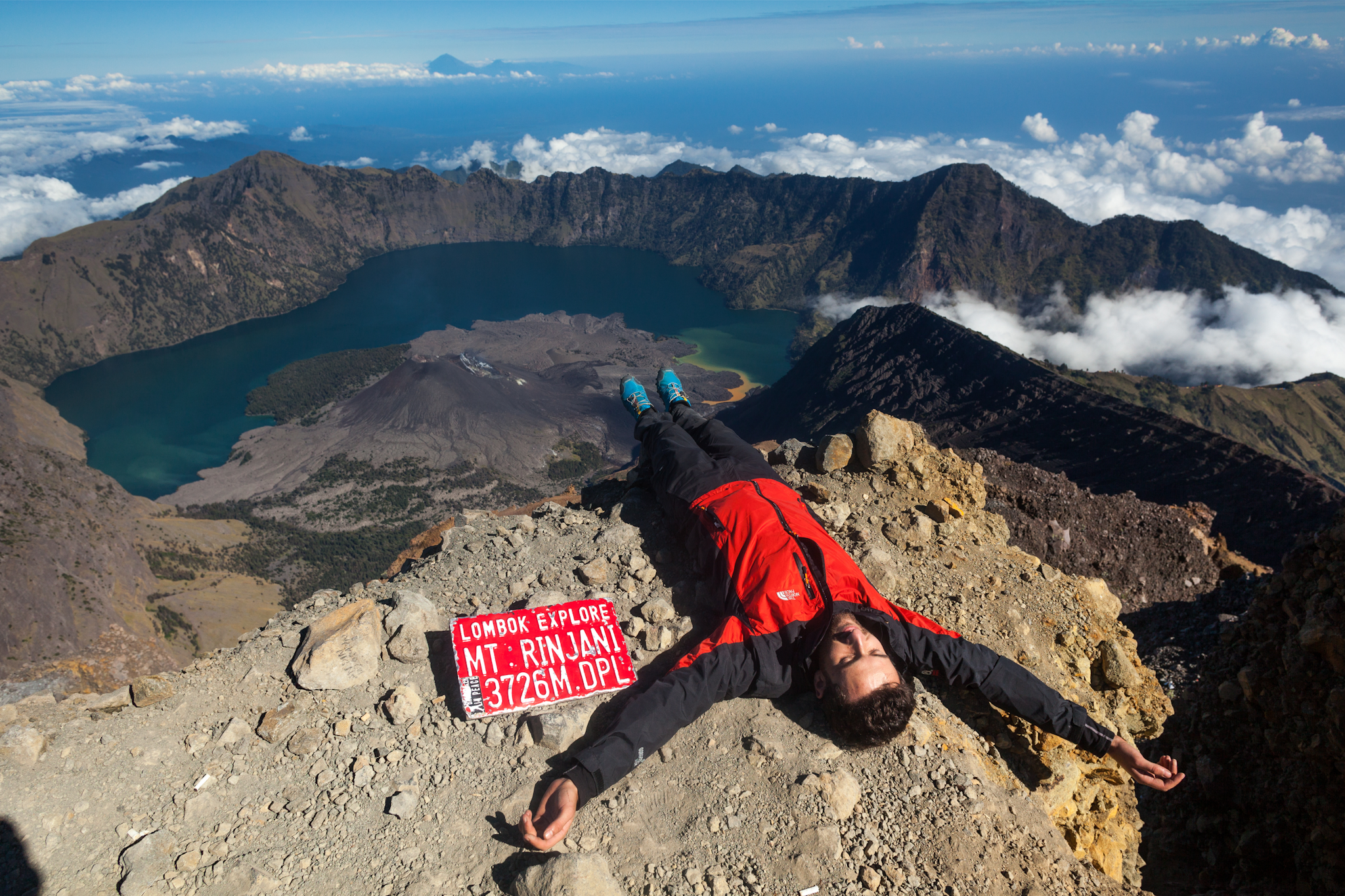Man lying at the summit of Mount Rinjani, Indonesia. Photo: Canva