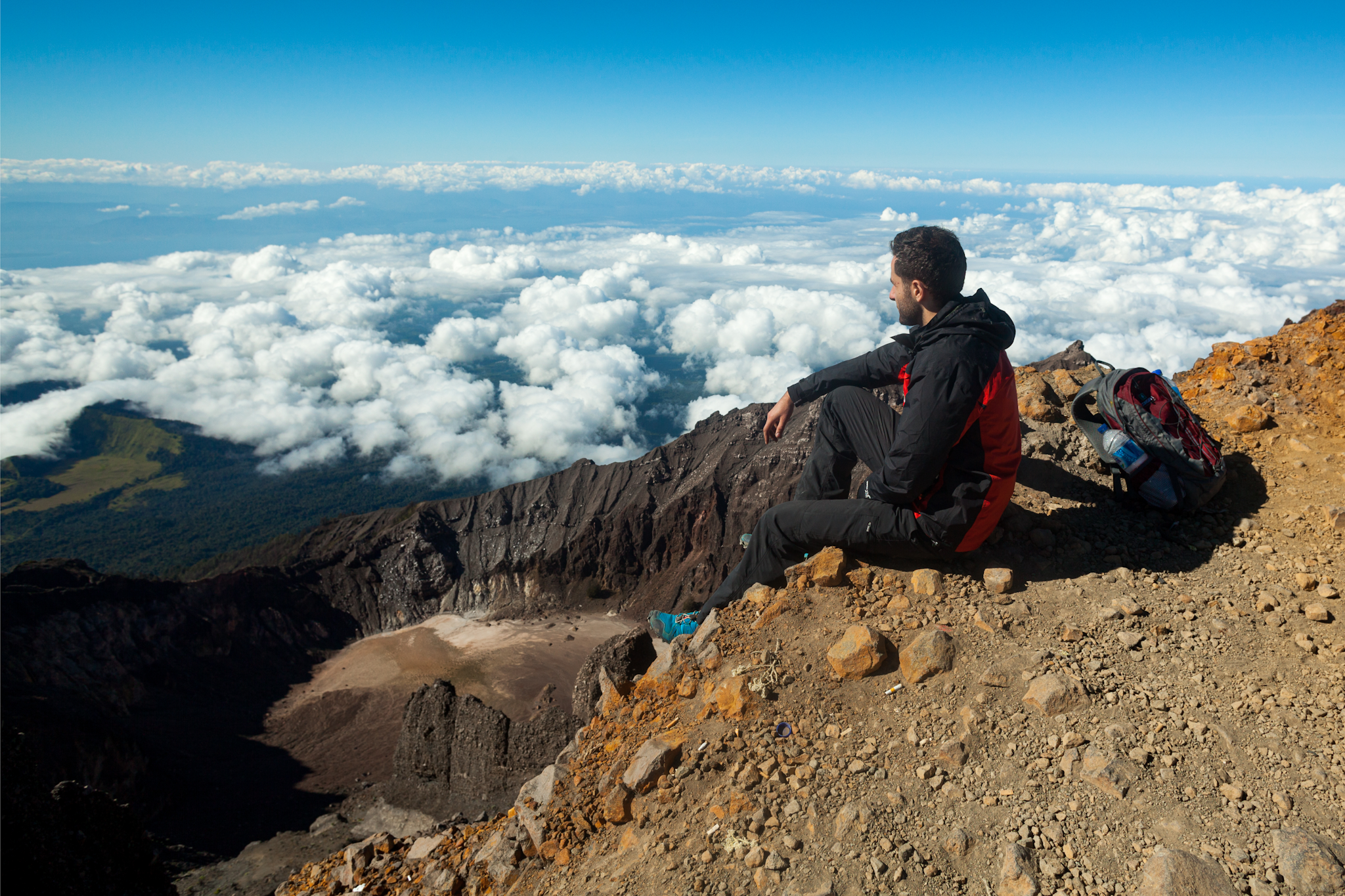 Man looking out over clouds on Mount Rinjani, Indonesia. Photo: Canva
