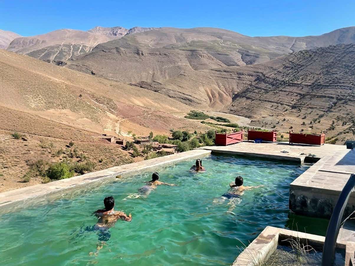 Swimmers in the outdoor pool at Touda Ecolodge in the Atlas Mountains, Morocco