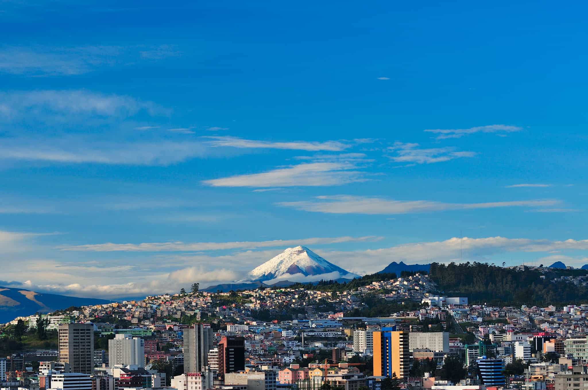 Cityscape of Quito, capital of Ecuador, with the volcano Cotopaxi in the background.