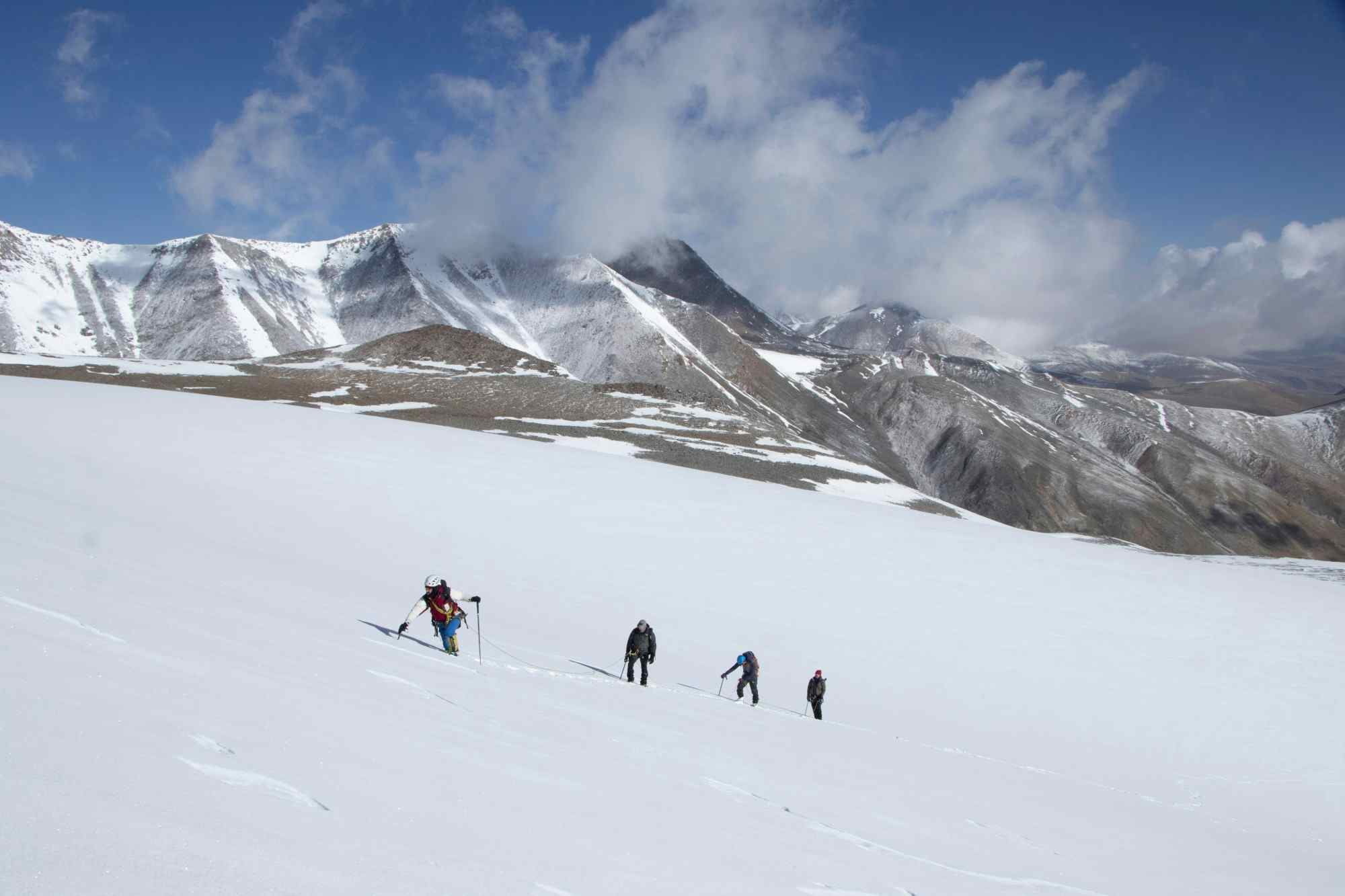 Four climbers ascending the snow fields of UT Kangri in Ladakh, India