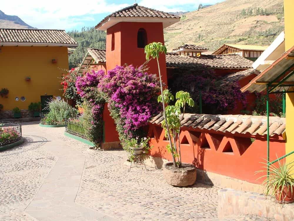 A red building with purple Bougainvillea plant growing in an archway