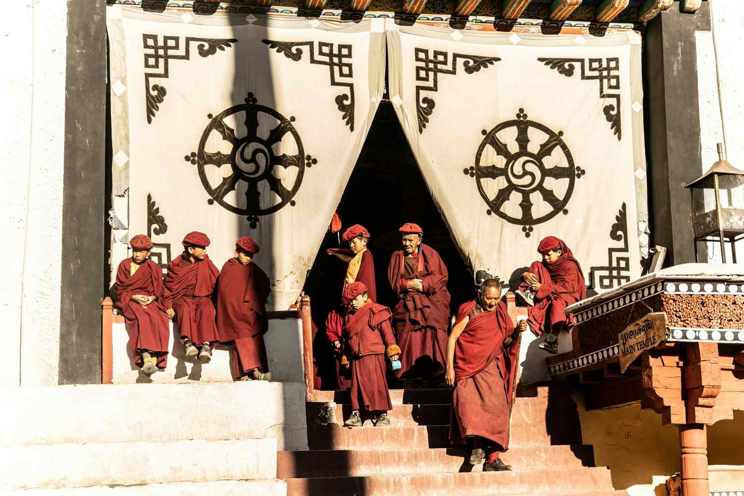 Red-robed Buddist monks descending stairs outside the Hemis Monastery in Ladakh, India