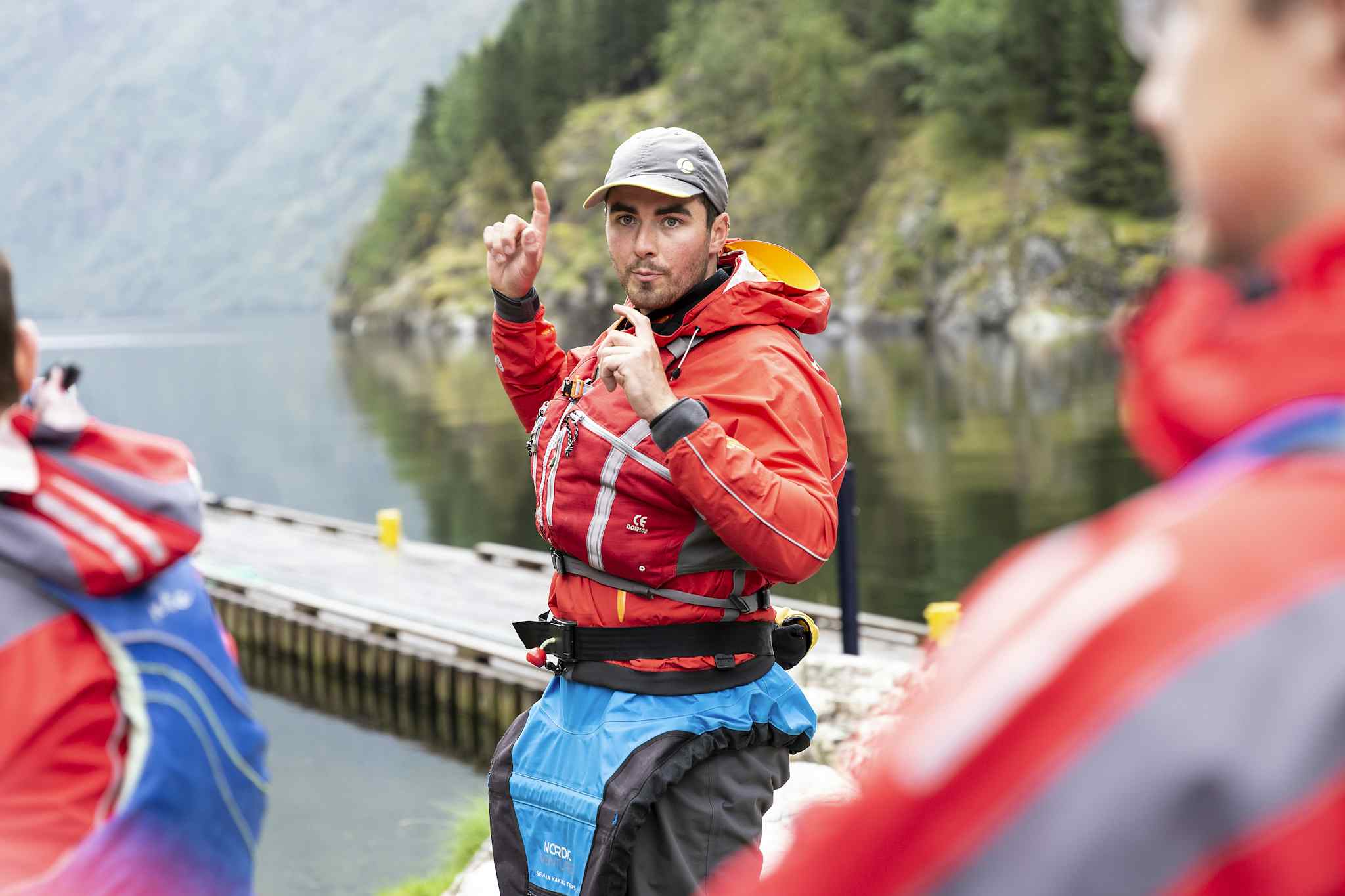 A kayaking guide takes guests through a safety briefing on the edge of the Nærøyfjord, Norway. 