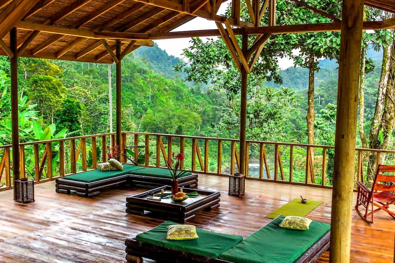 Balcony of an eco lodge overlooking jungle foliage and a river