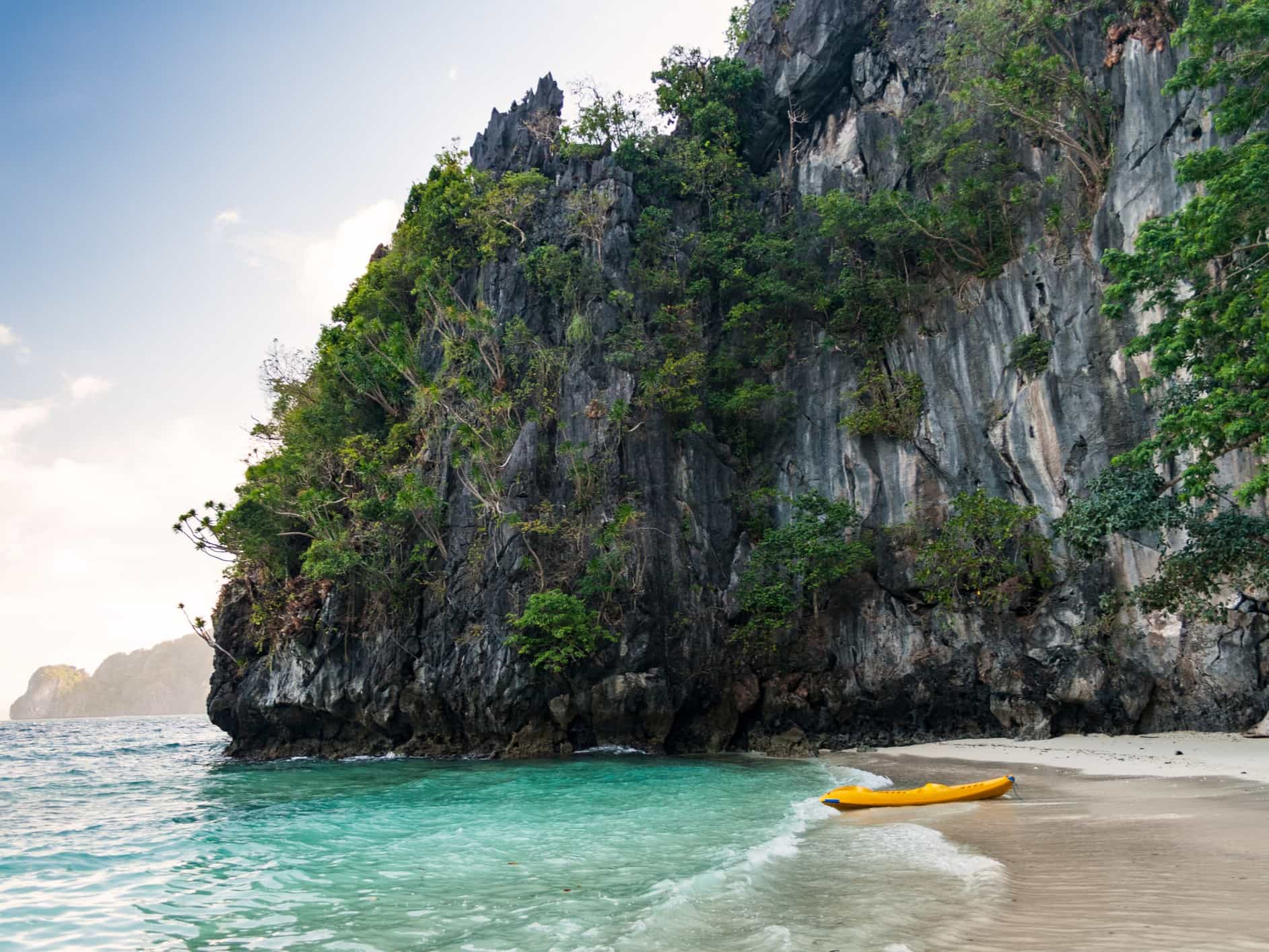 Yellow kayak on a beach off Miniloc Island, El Nido region of Palawan in the Philippines.