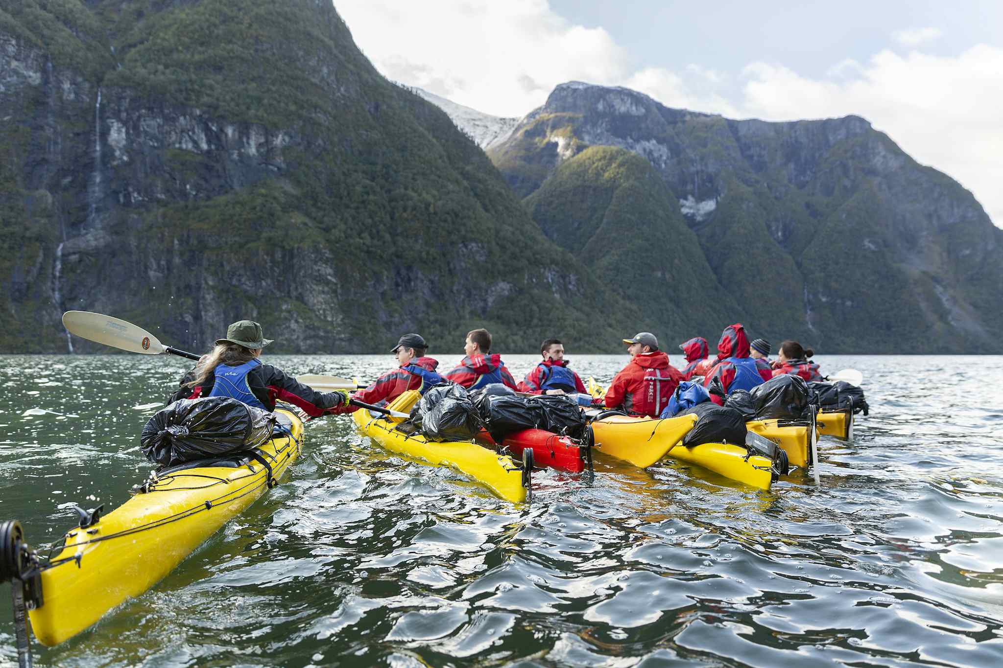 A group of kayakers stop for a rest on the waters of the Naeroyfjord in the Norwegian Fjords.
