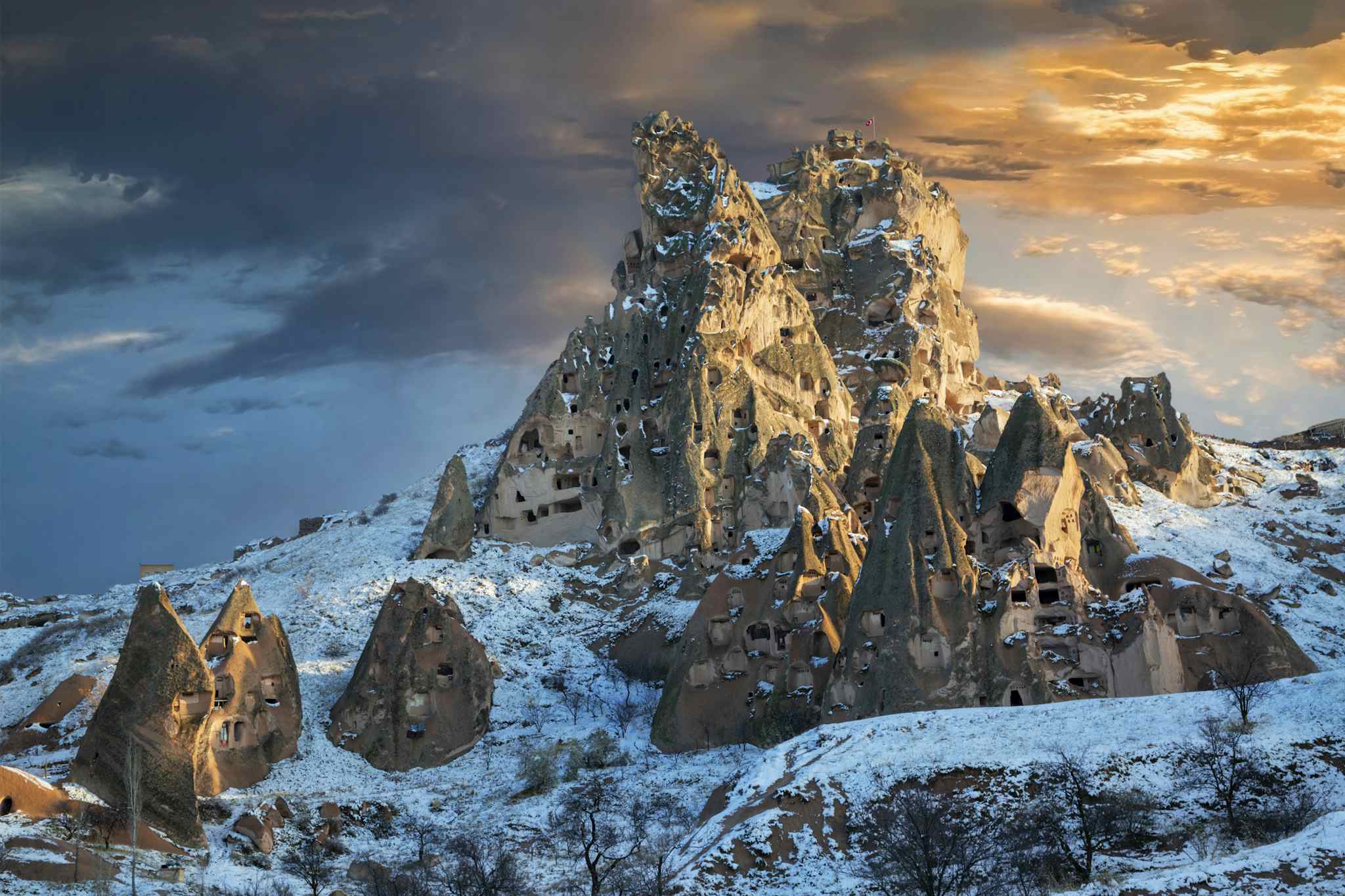 Volcanic rock formations in the town of Uchisar in the snow at the sunset in Cappadocia, Turkey. Photo: GettyImages-1313634518