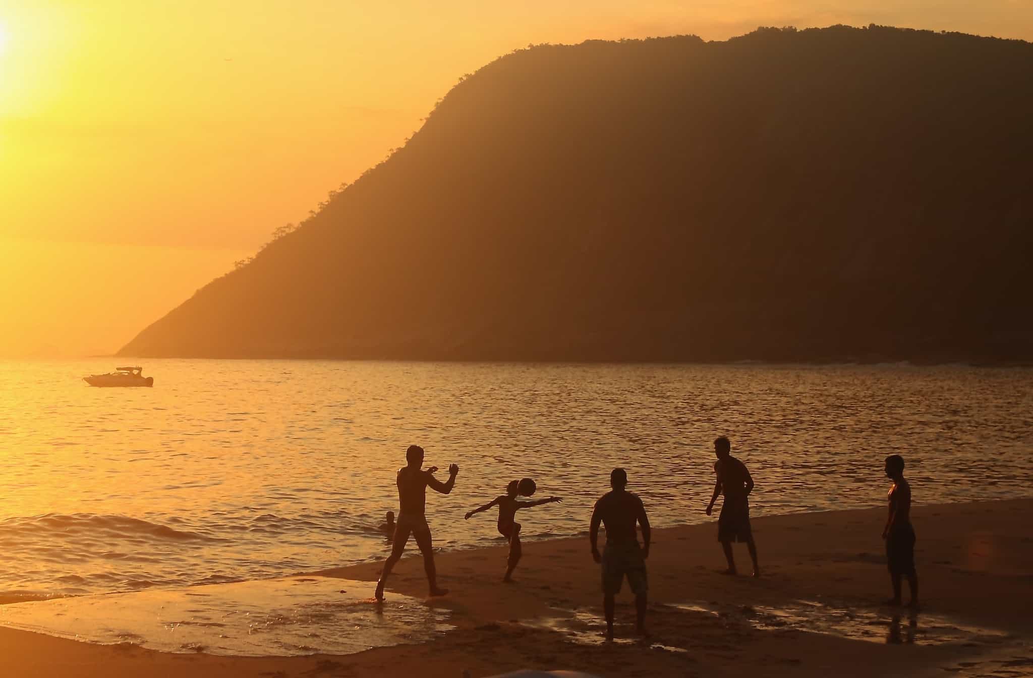 Footballers silhouetted on the beach in Rio de Janeiro at sunset