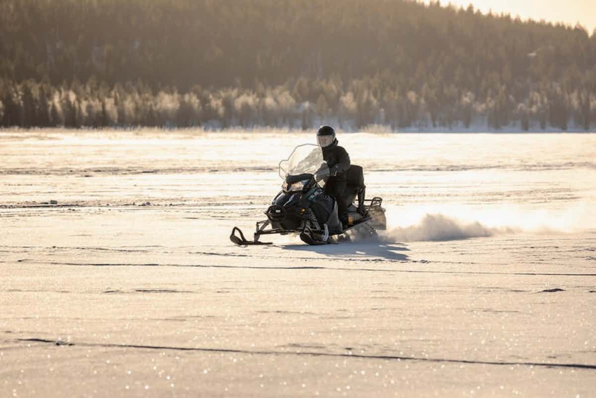 An electric snowmobile crossing a snowy plateau in Finnish Lapland.