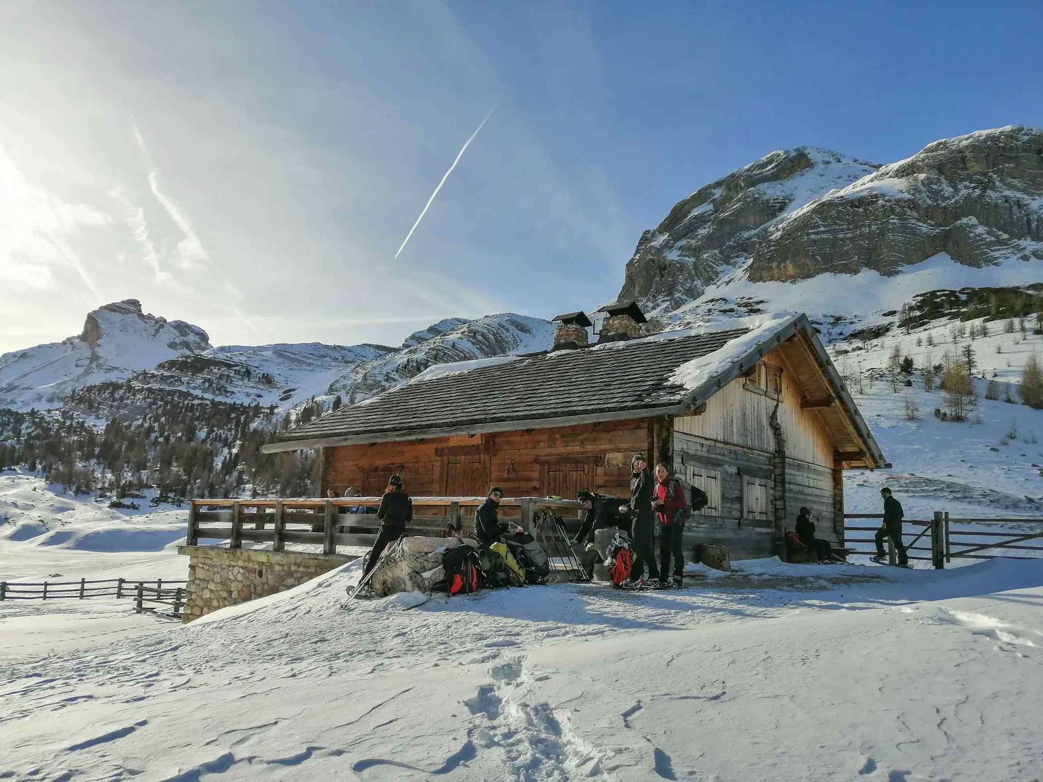Hikers in the snow outside a mountain hut in the Dolomites, Italy.