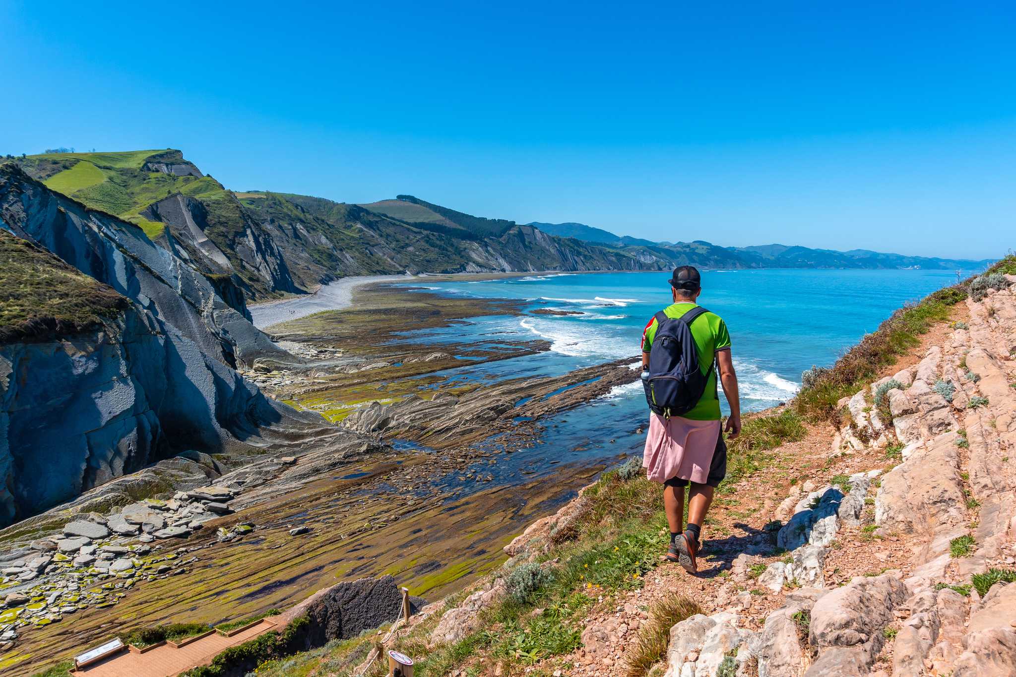 A man in Algorri cove on the coast in the Zumaia flysch, Gipuzkoa. Basque Country
