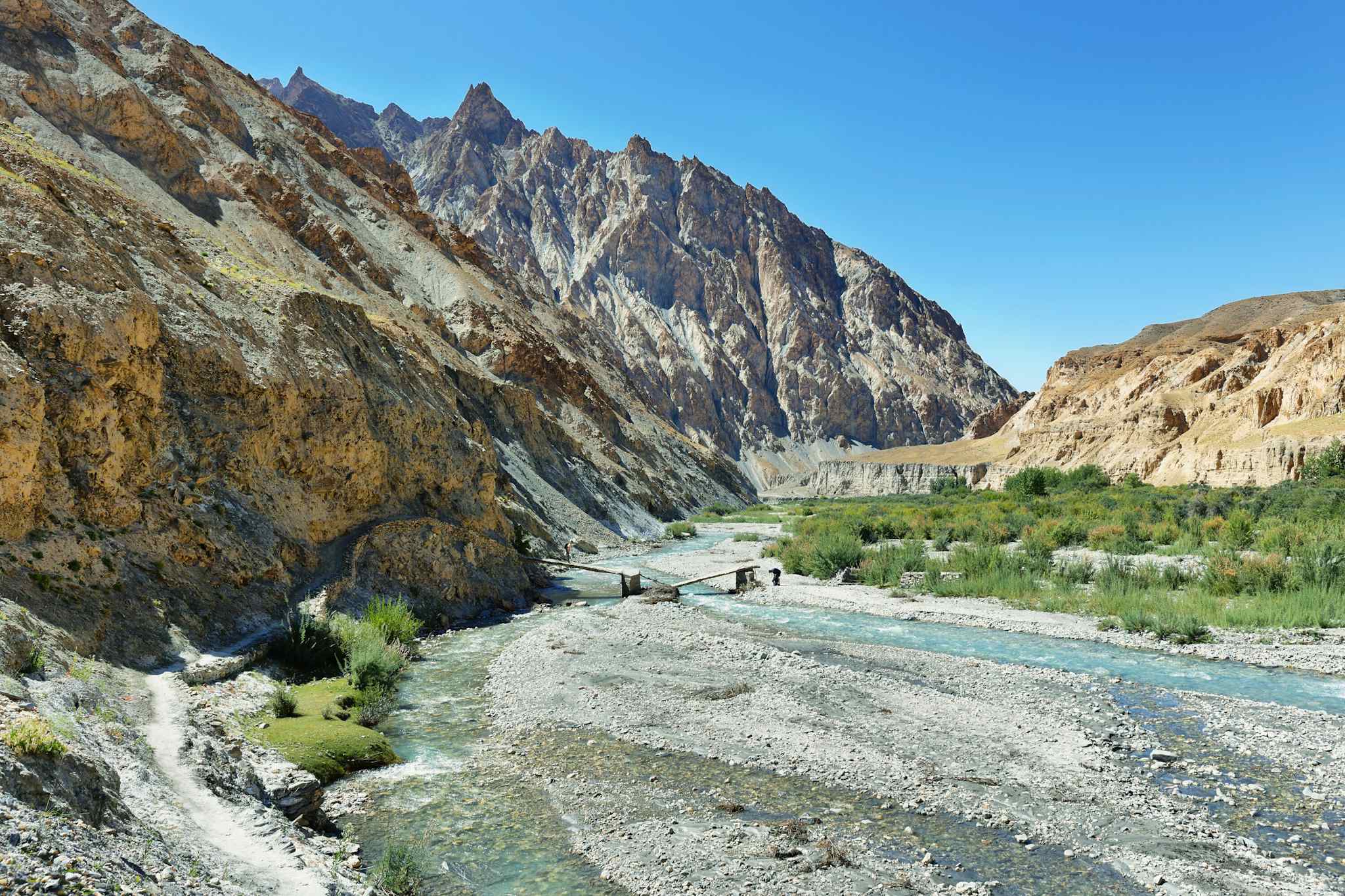 River flowing through the Markha Valley with rocky cliffs behind in Ladakh, India.
