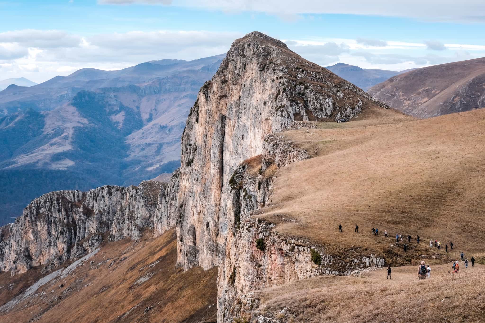 A group of tourists climbing up Mount Dimats on cloudy autumn day. Dilijan National Park, Tavush Province, Armenia.
