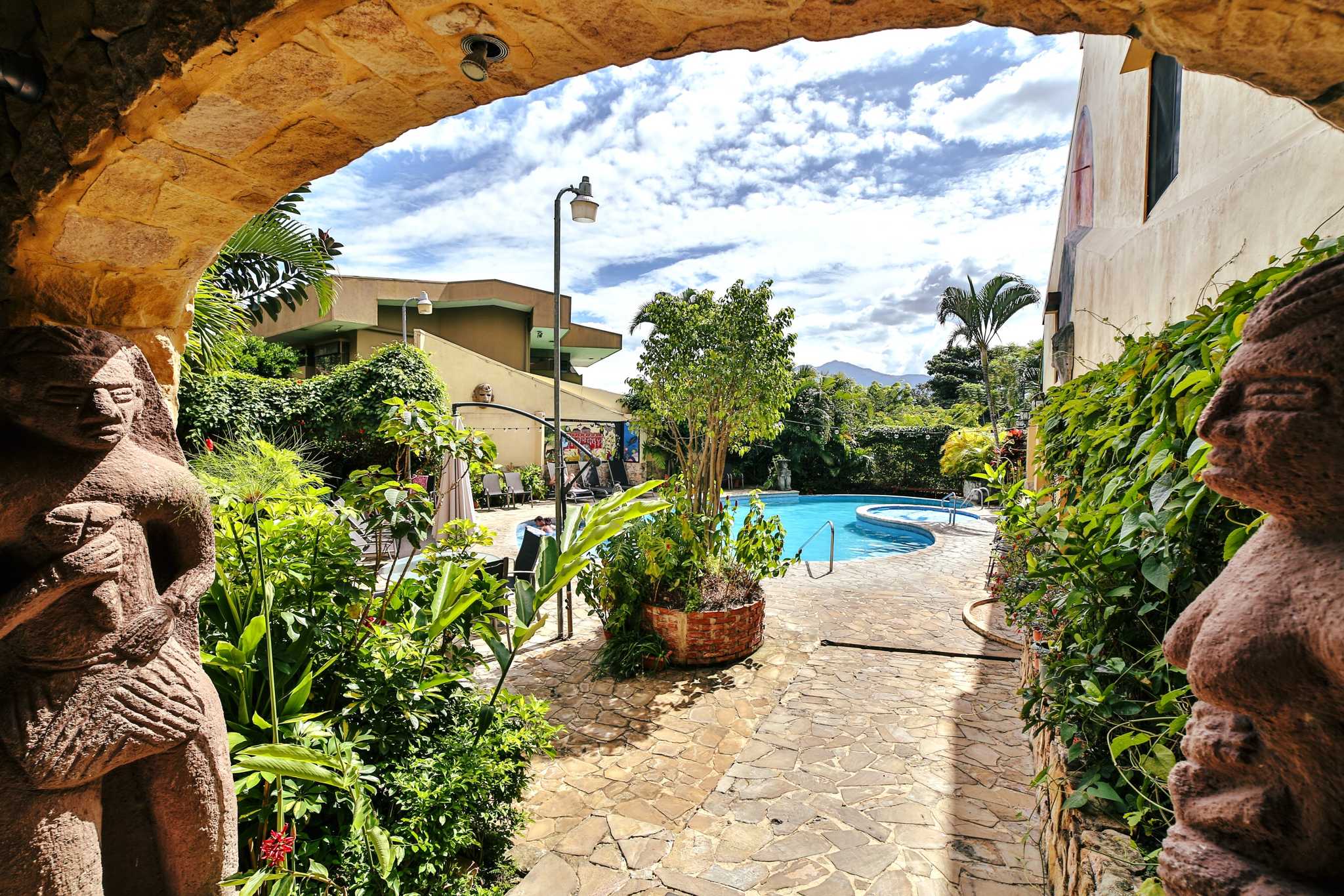 View through an archway of a swimming pool in a garden