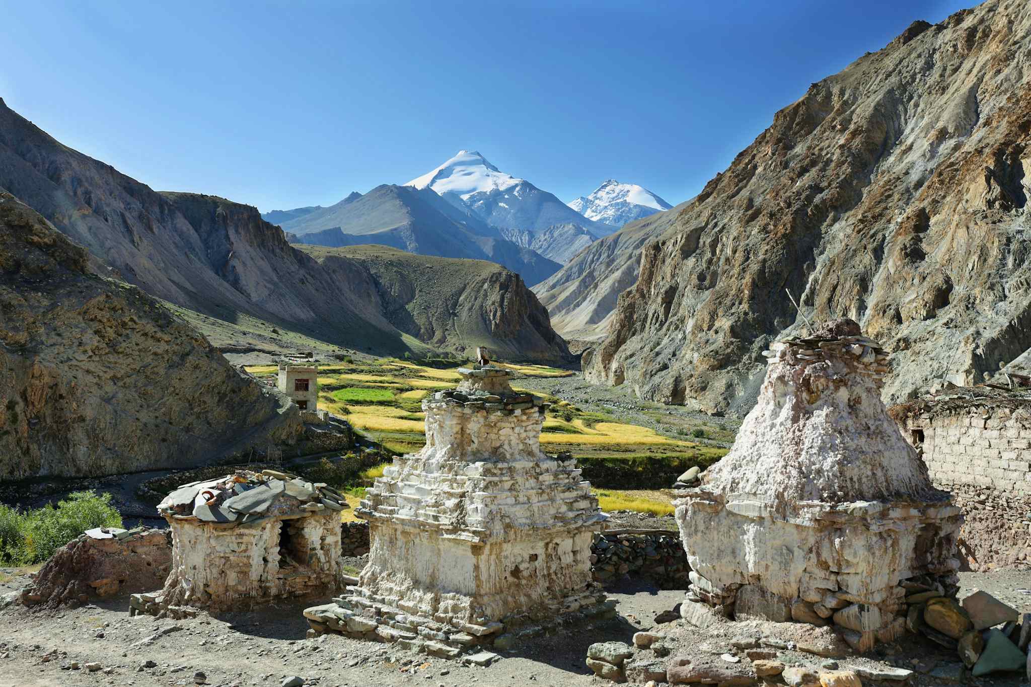 View of Kang Yatse from the Markha Valley trek, with ruined stupas in the foreground in Ladakh, India.