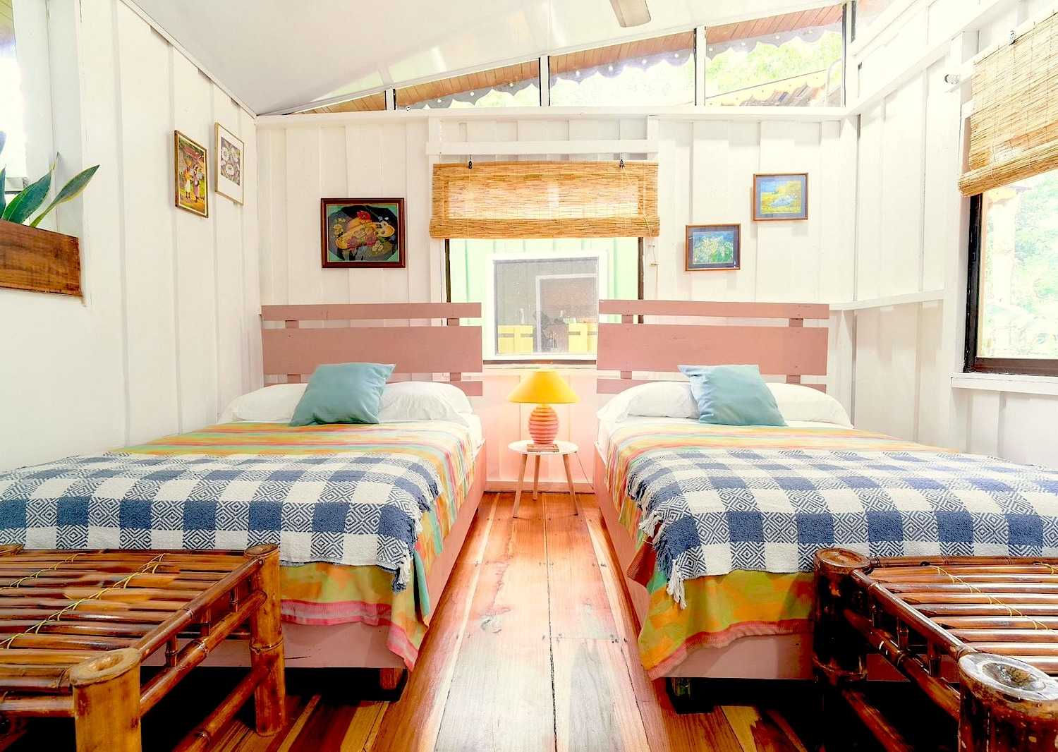 two twin beds in a wooden cabin decorated with blue checked sheets