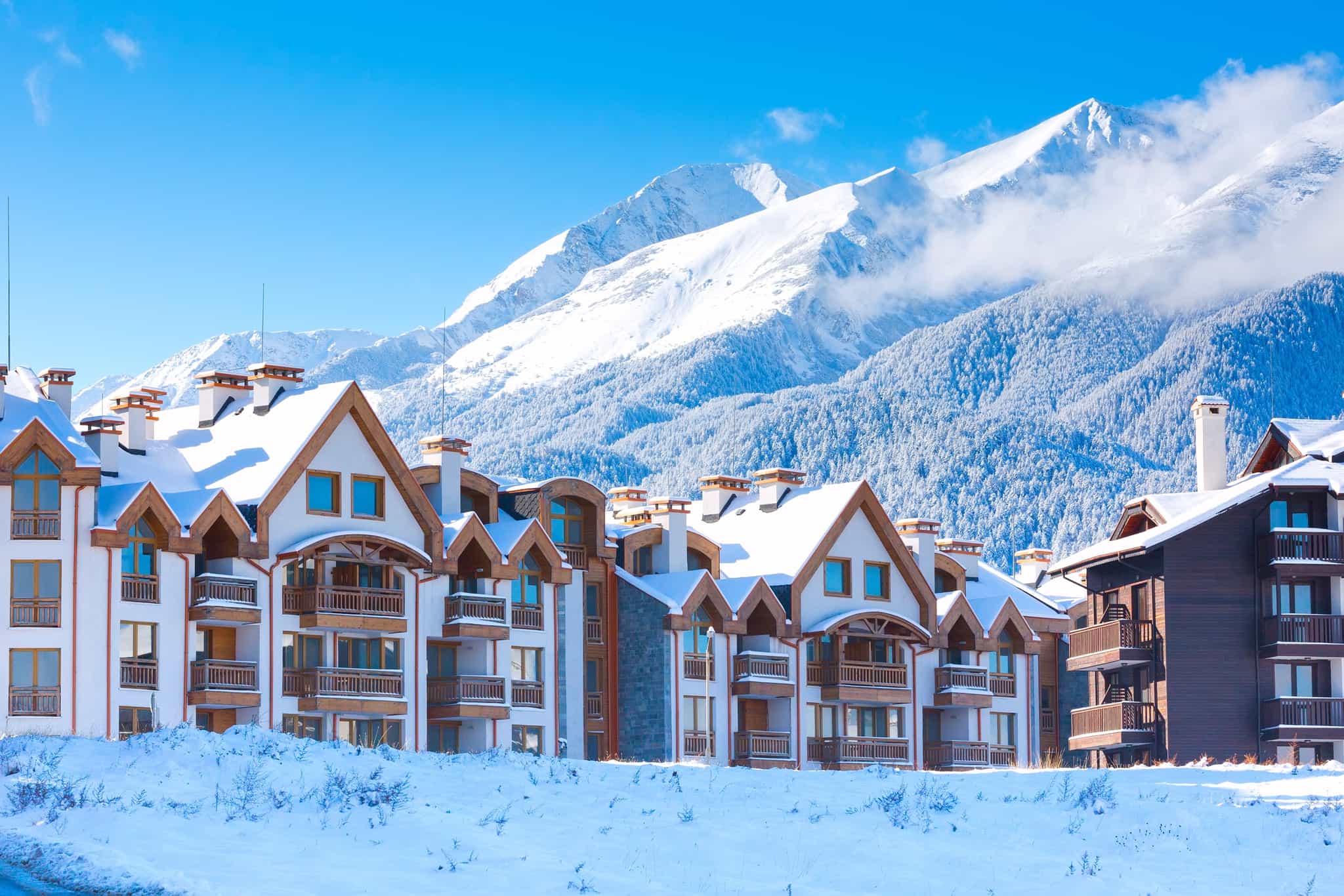 Snow covered chalets with a mountain backdrop in Bankso, Bulgaria