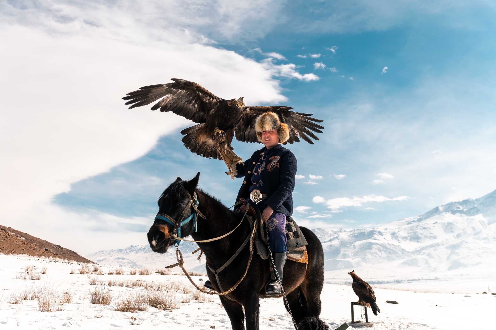 Eagle hunter sitting on a horse with eagle in hand