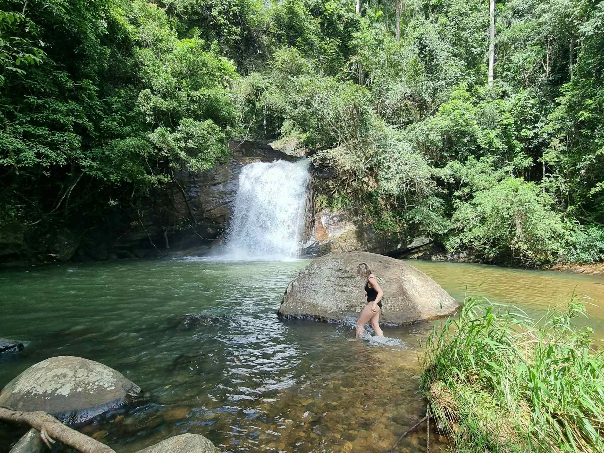 Woman swimming in a waterfall, Sri Lanka.
