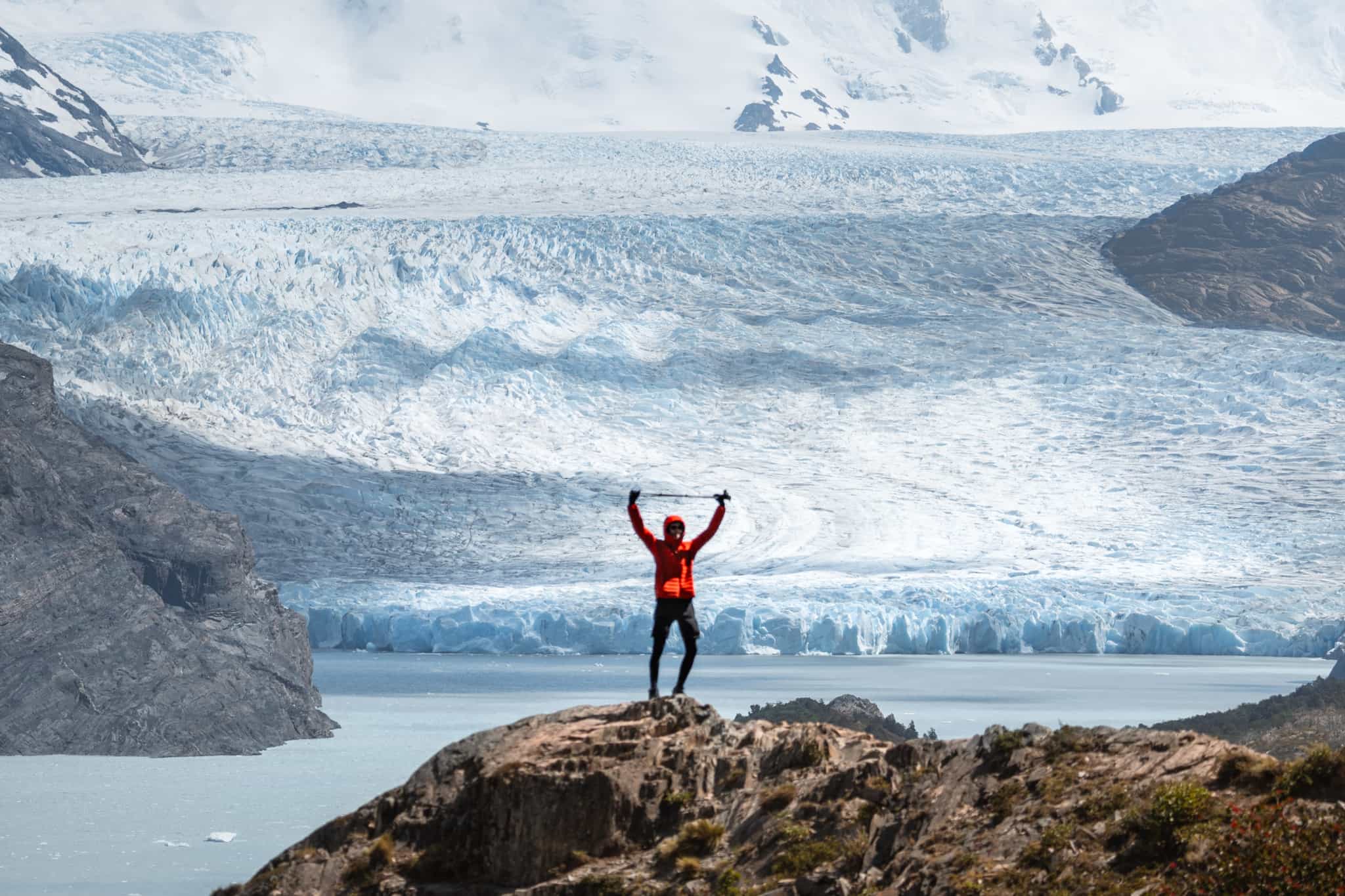 Hiker stands on the windy outcrop above Lago Grey