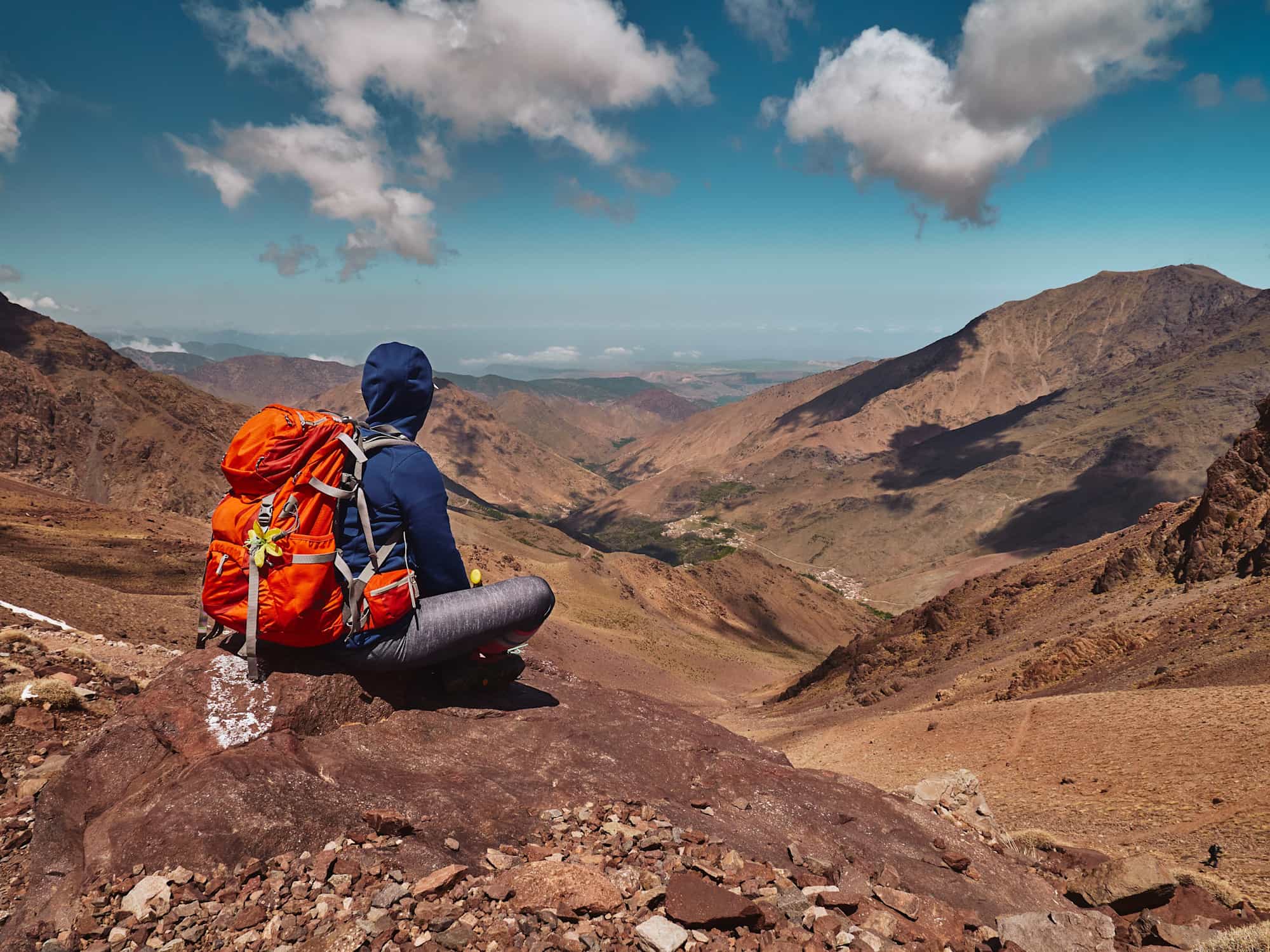 Hiker sits on top of a pass enjoying the view in the Atlas Mountains