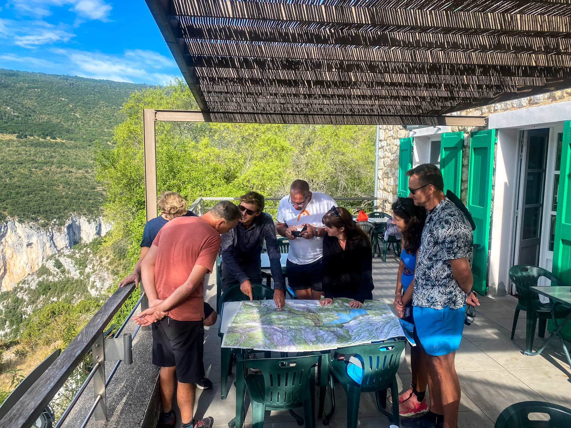 Group of adventurers looking at a map in the Verdon Gorge, Provence, France.