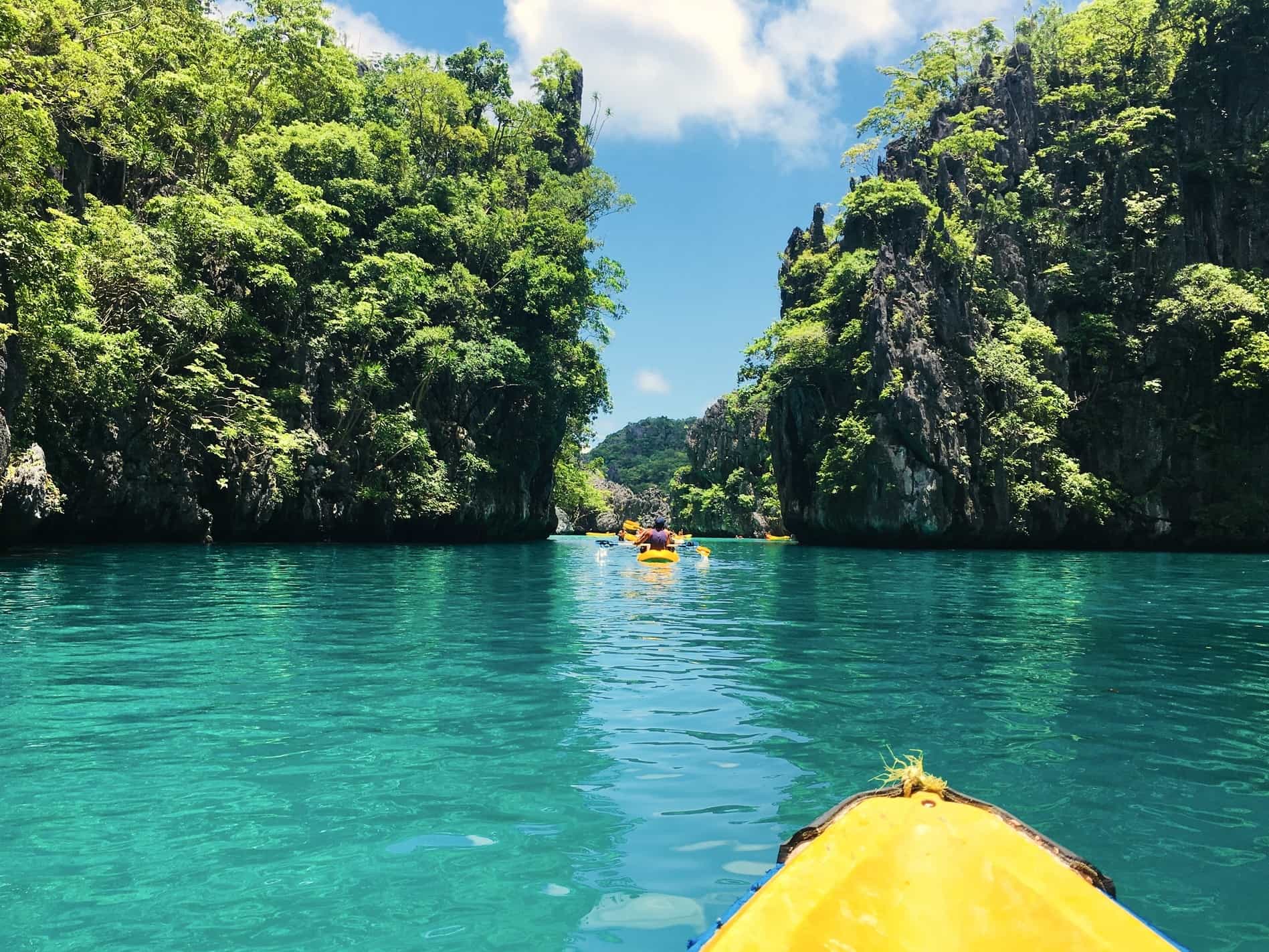 People kayaking on a blue lagoon in Philippines