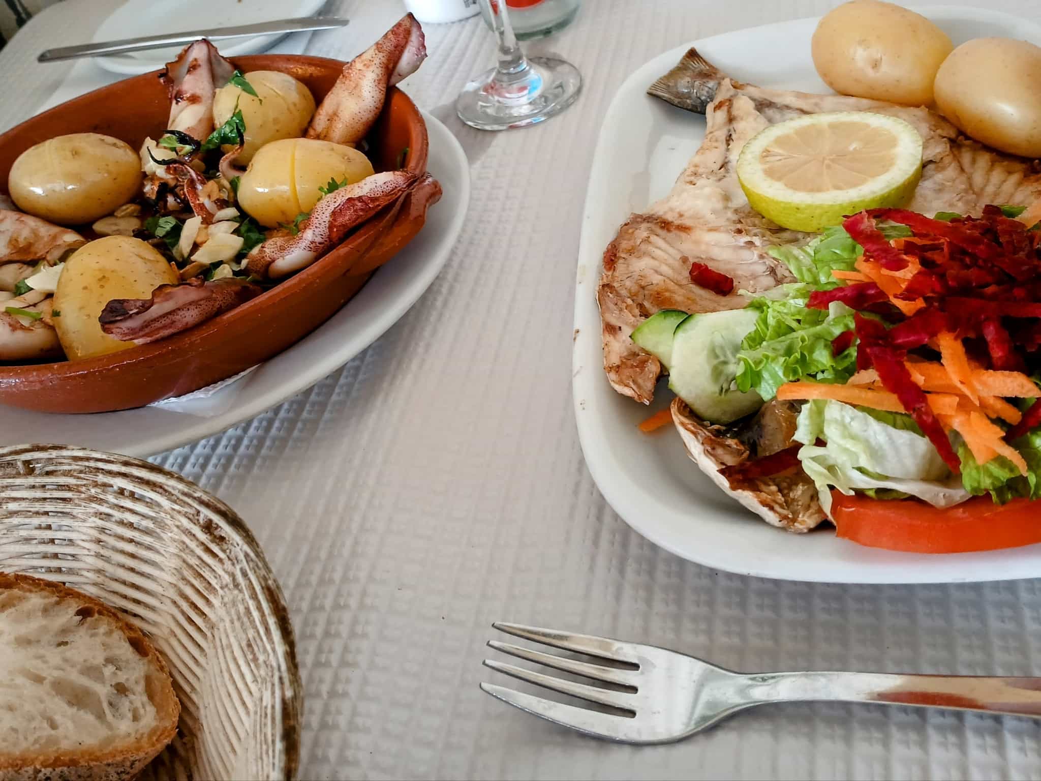 A selection of seafood and vegetable dishes on a restaurant table.