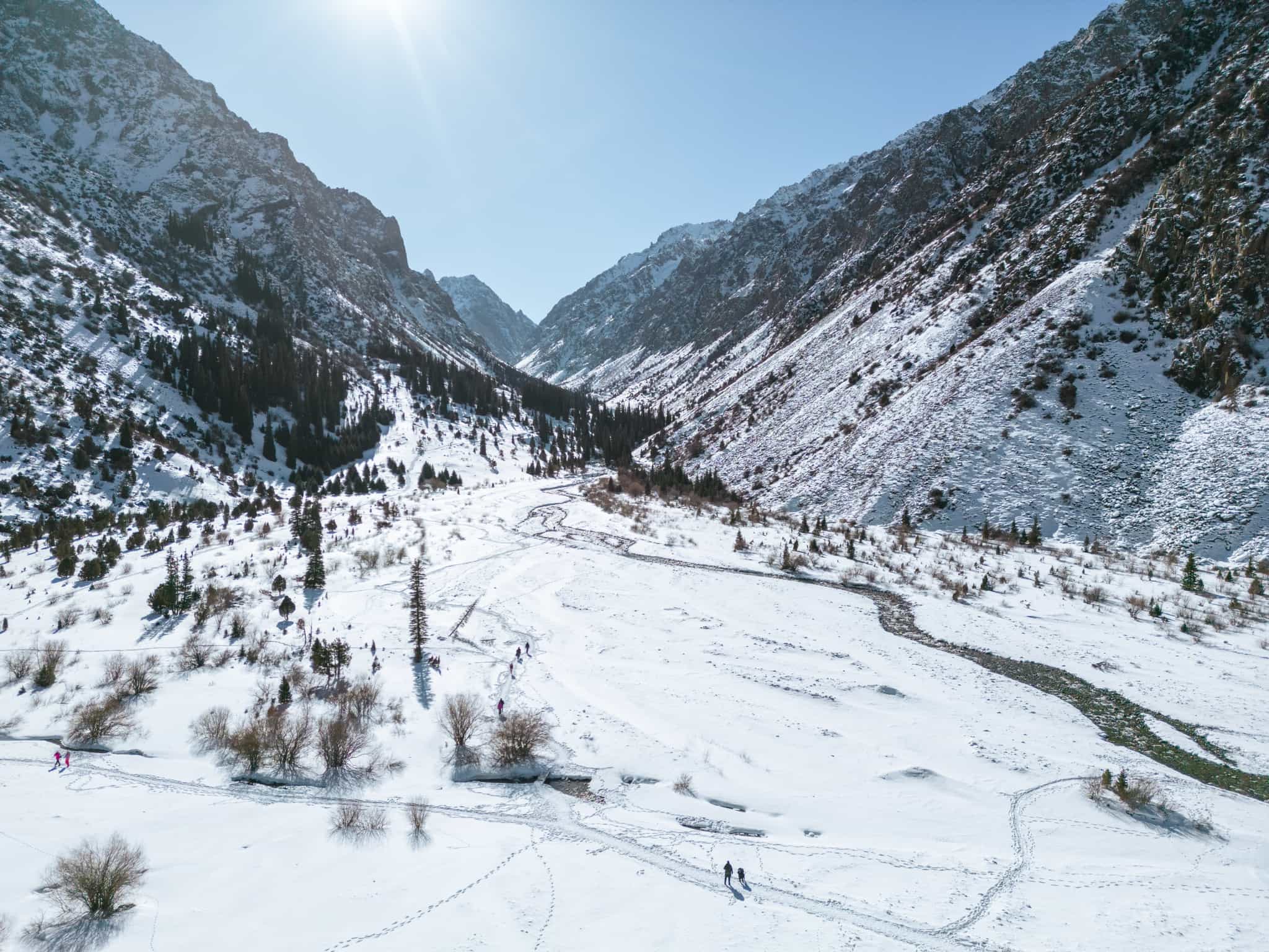 Hikers crossing the snow in Ala Archa National Park, Kyrgyzstan