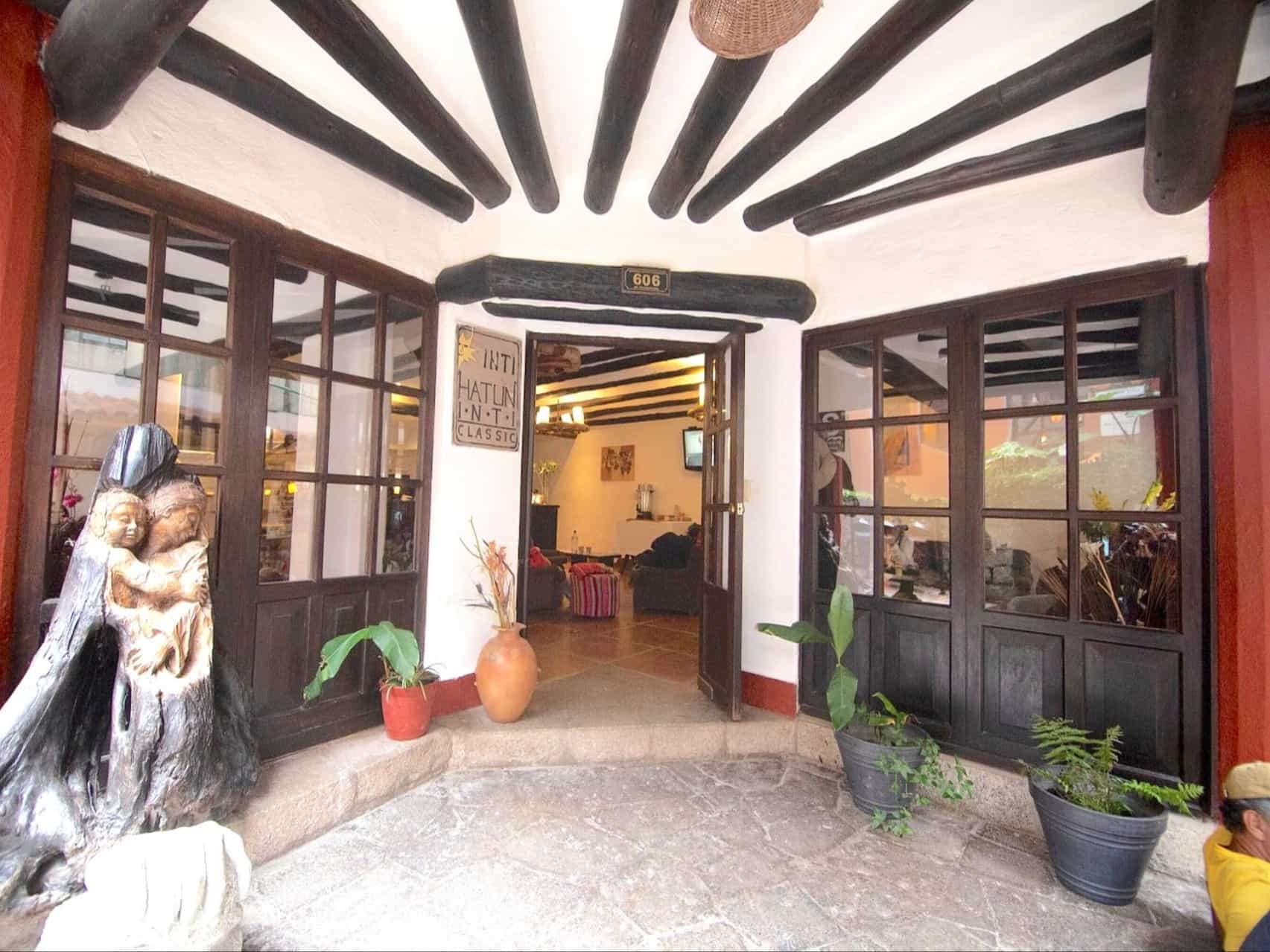 The Entrance Door of a hotel with white walls and dark wood decoration