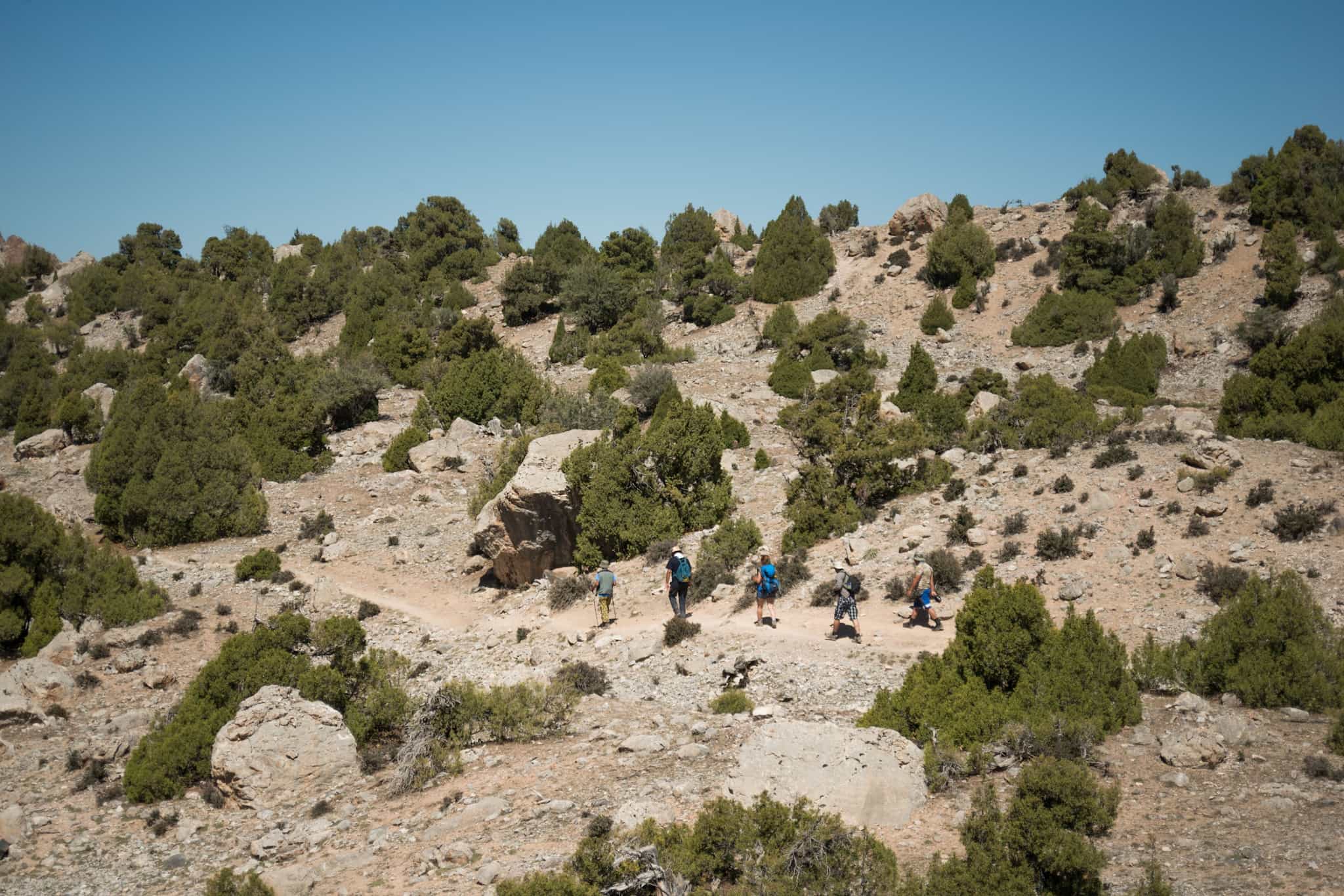Hikers walking on a dusty trail towards Zimtut