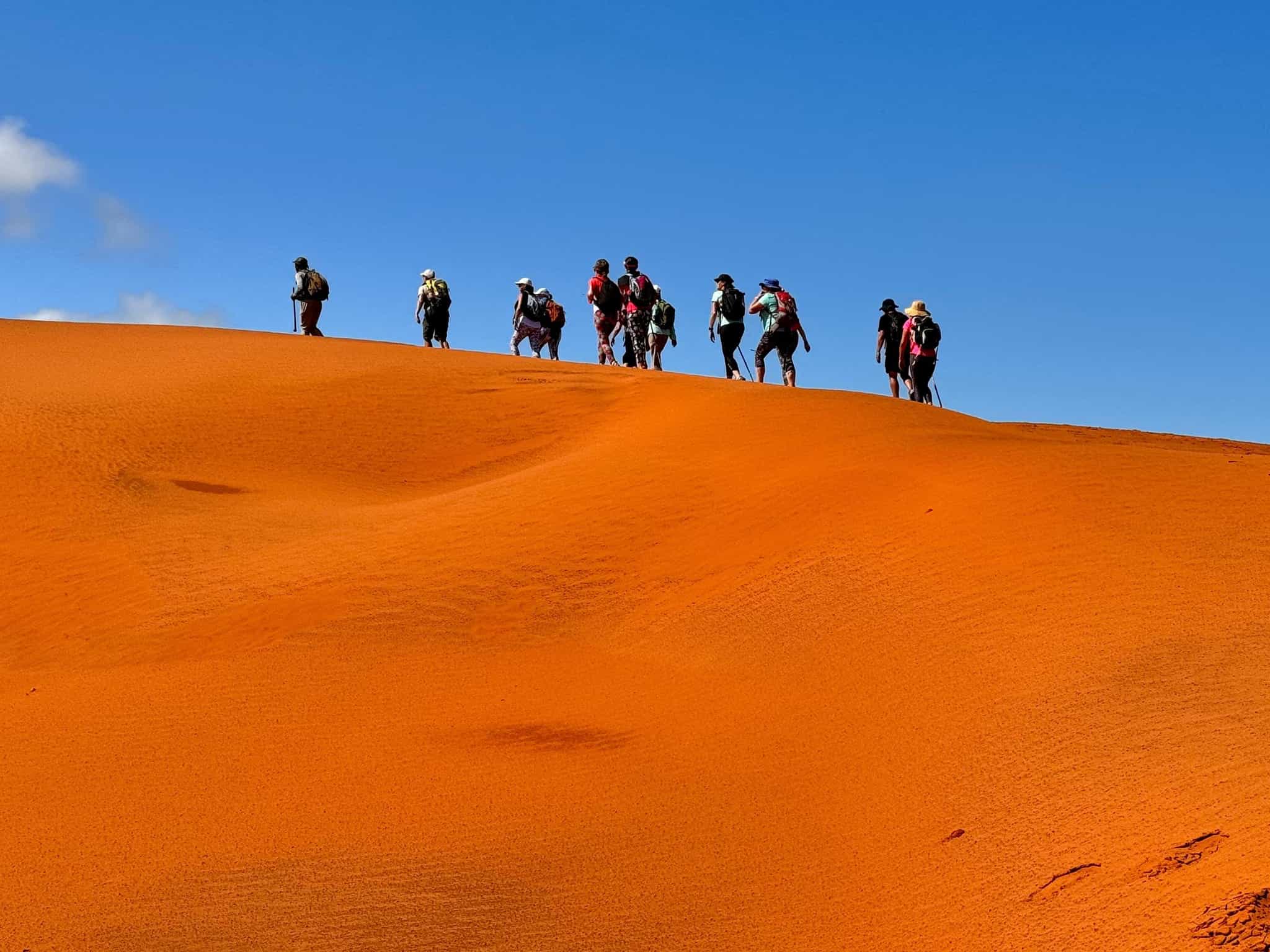 Hikers on the red dunes of Mtentu, South Africa.