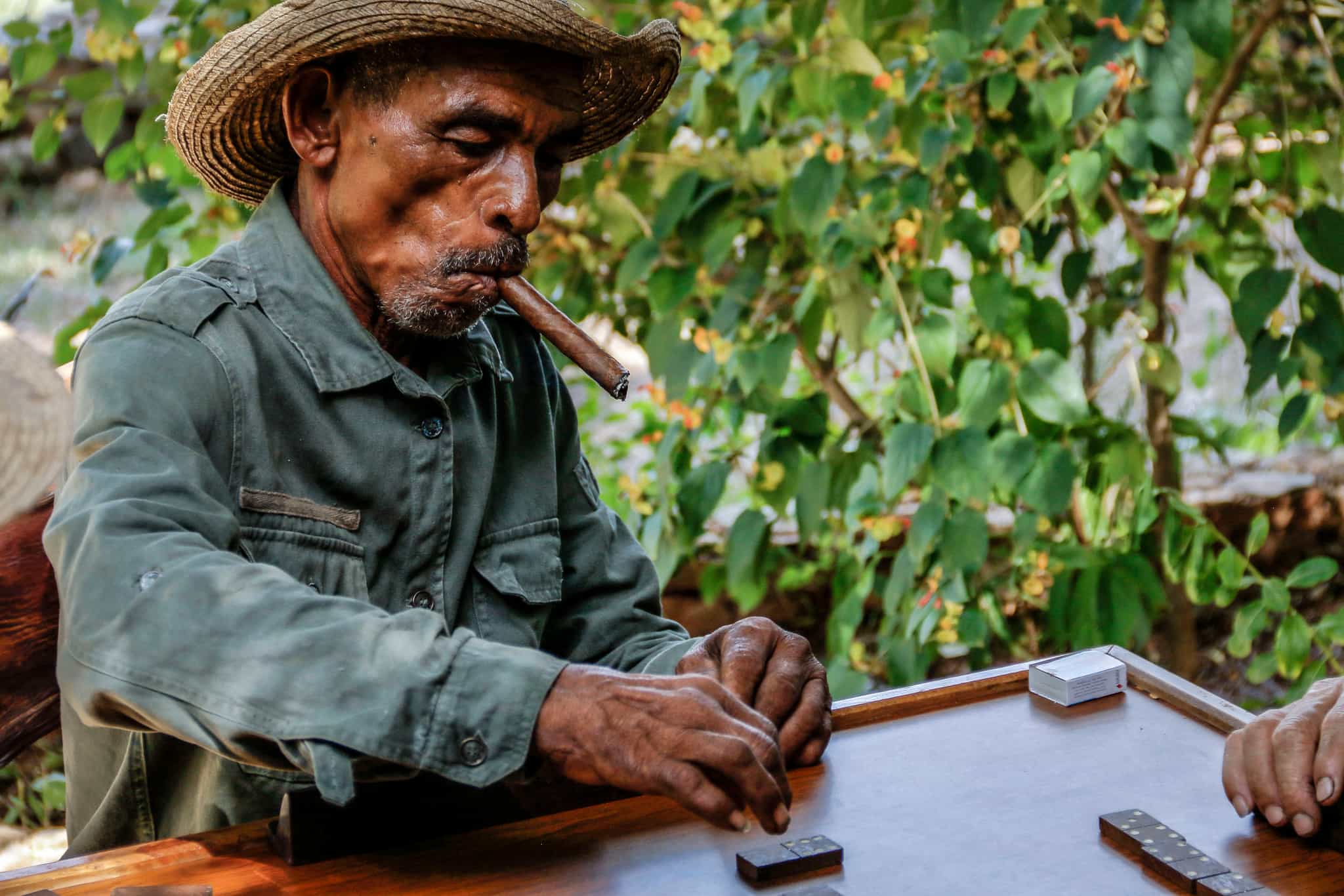 Cuban man smoking a cigar and playing dominoes