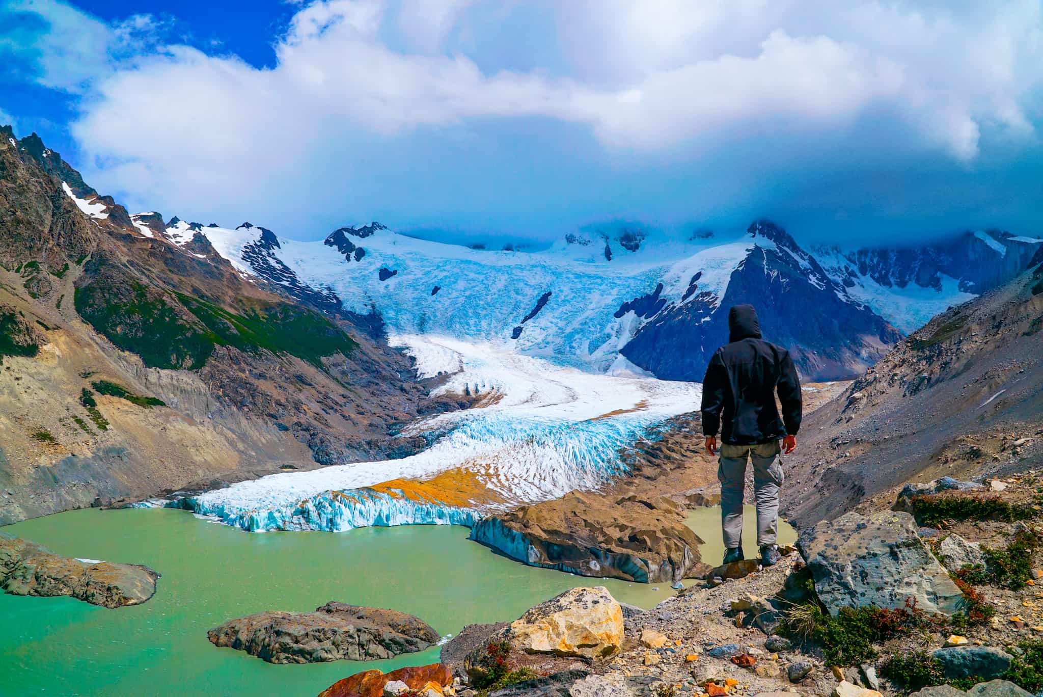 Man stands overlooking a glacier at the Cerro Torre viewpoint