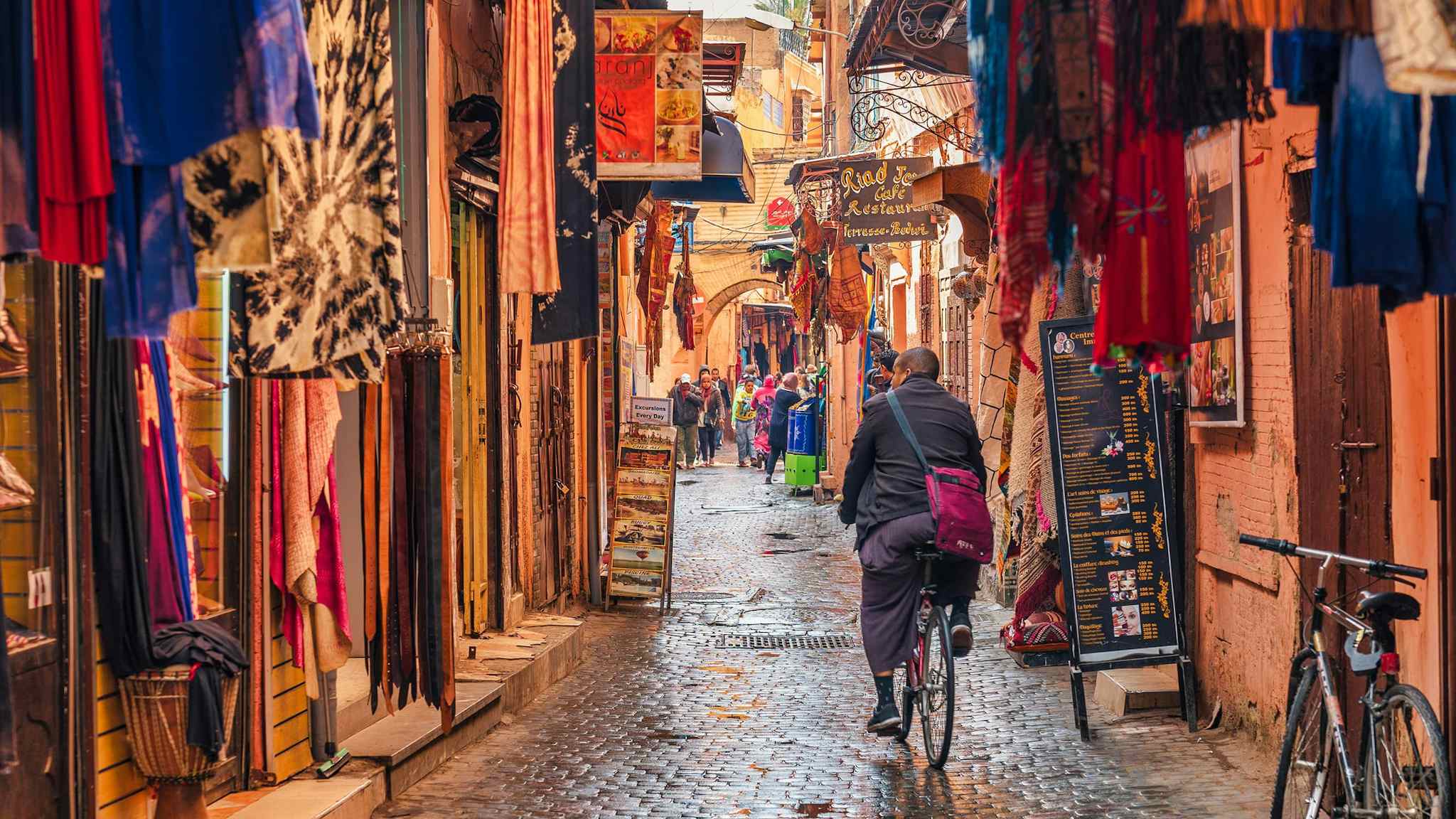 A cyclist cycles the back streets of Jamaa el Fna Market in Marrakesh, Morocco. 