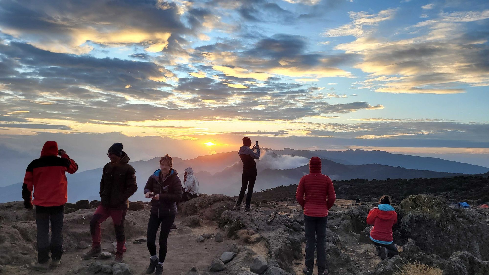 Trekkers viewing the sunset from Shira Camp on Kilimanjaro, Tanzania.