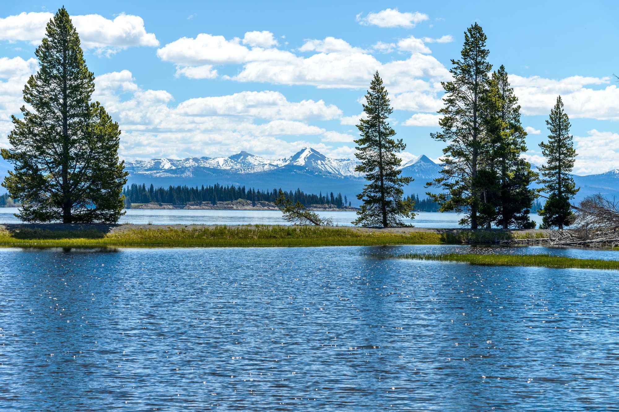 A spring view of Yellowstone Lake with snow-capped mountain range in the background, Yellowstone National Park, Wyoming, USA. Photo: Getty