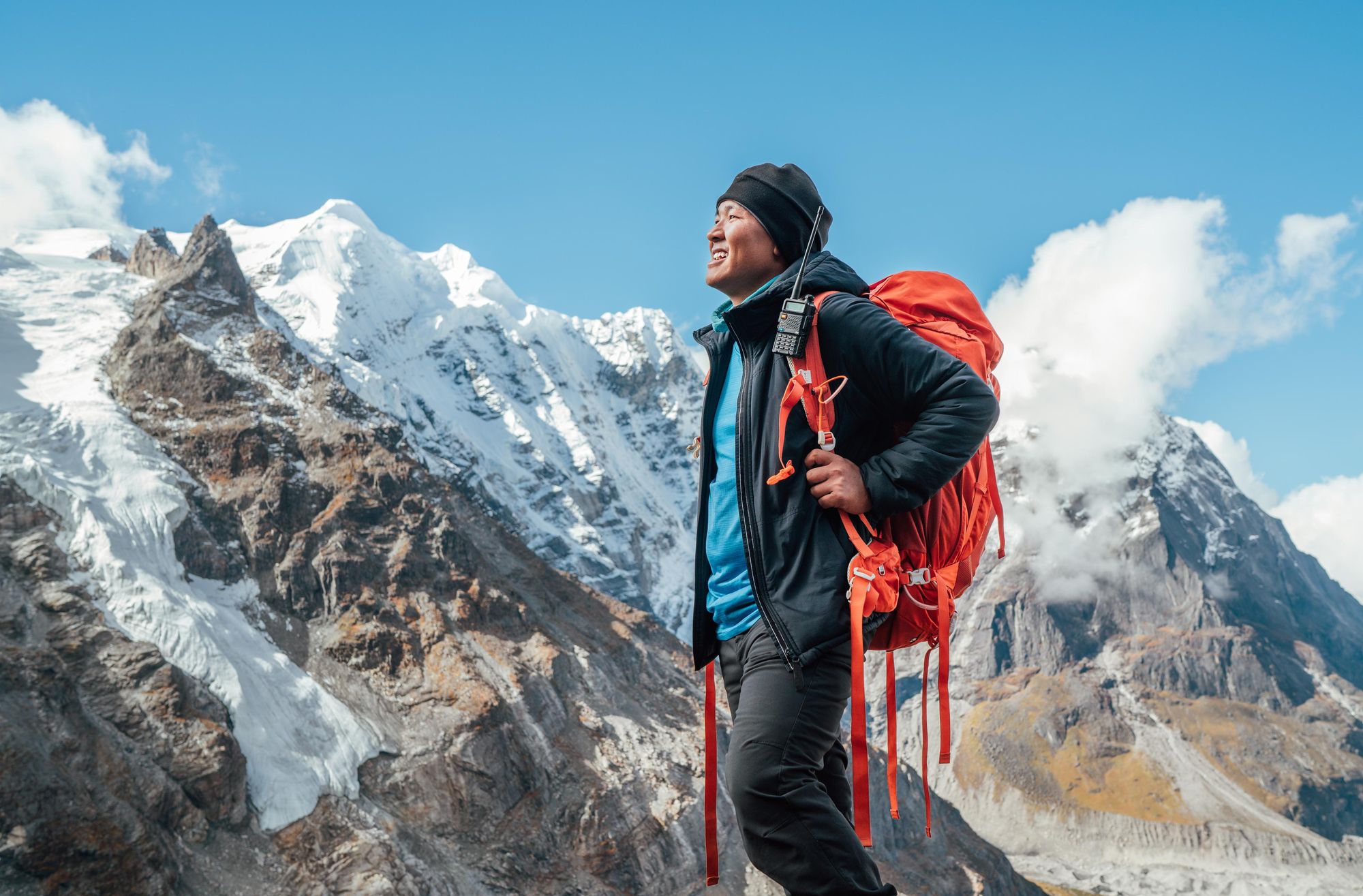 A smiling Sherpa man in front of the 6,476m (21,246ft) Mera Peak in the Himalayas of Nepal. Photo: Getty