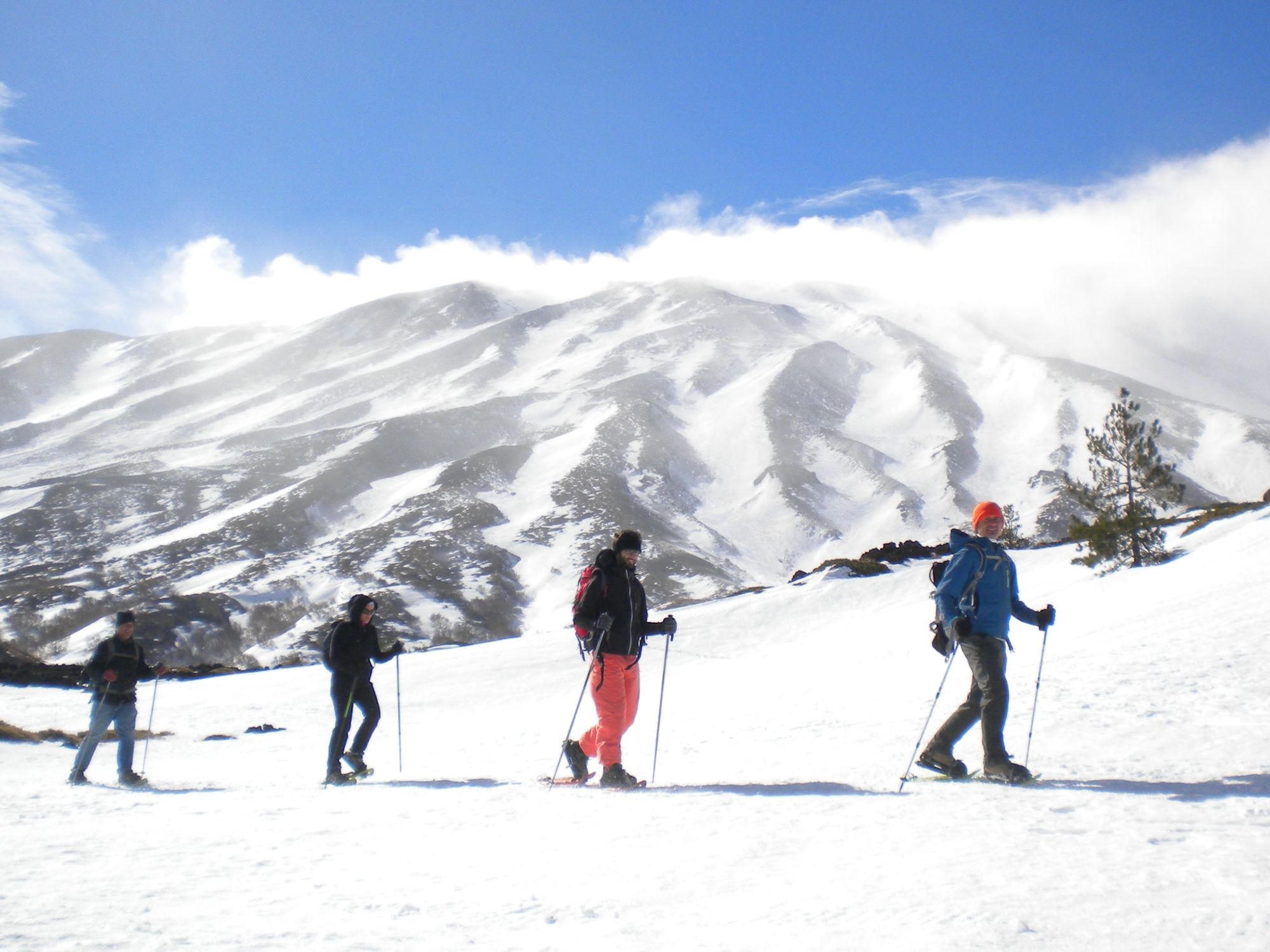 Hikers wearing snowshoes on a trail on Sicily's Mount Etna.