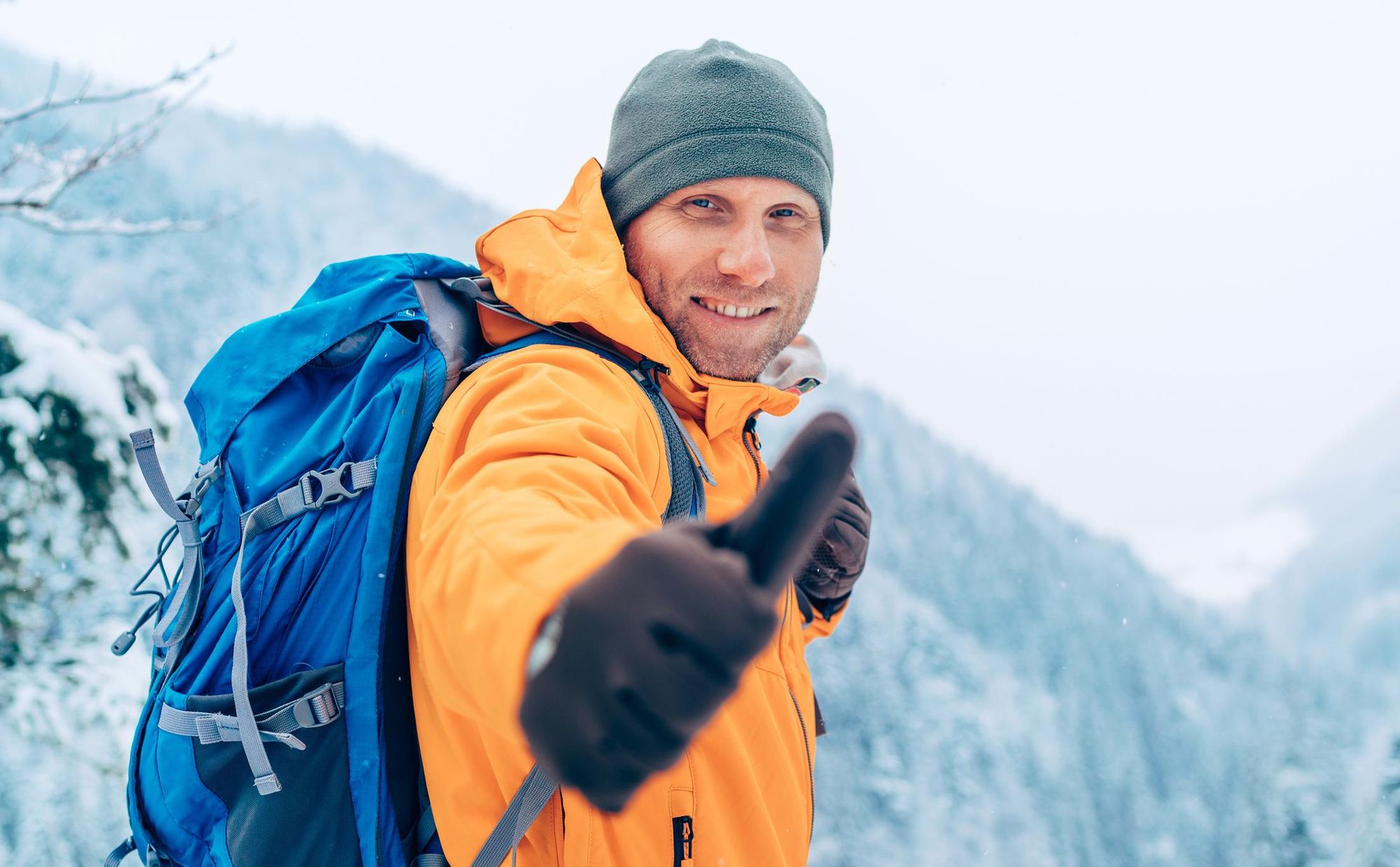 A male hiker in the snow, wearing appropriate cold weather clothing. Photo: Getty