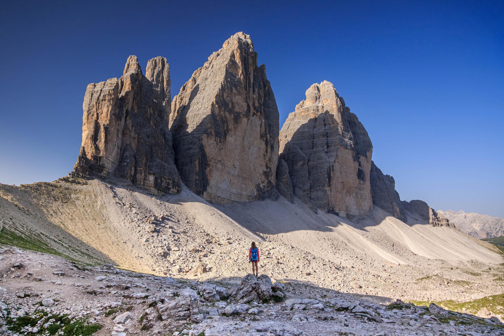 A hiker looking at the Tre Cime di Lavaredo in the Italian Dolomites