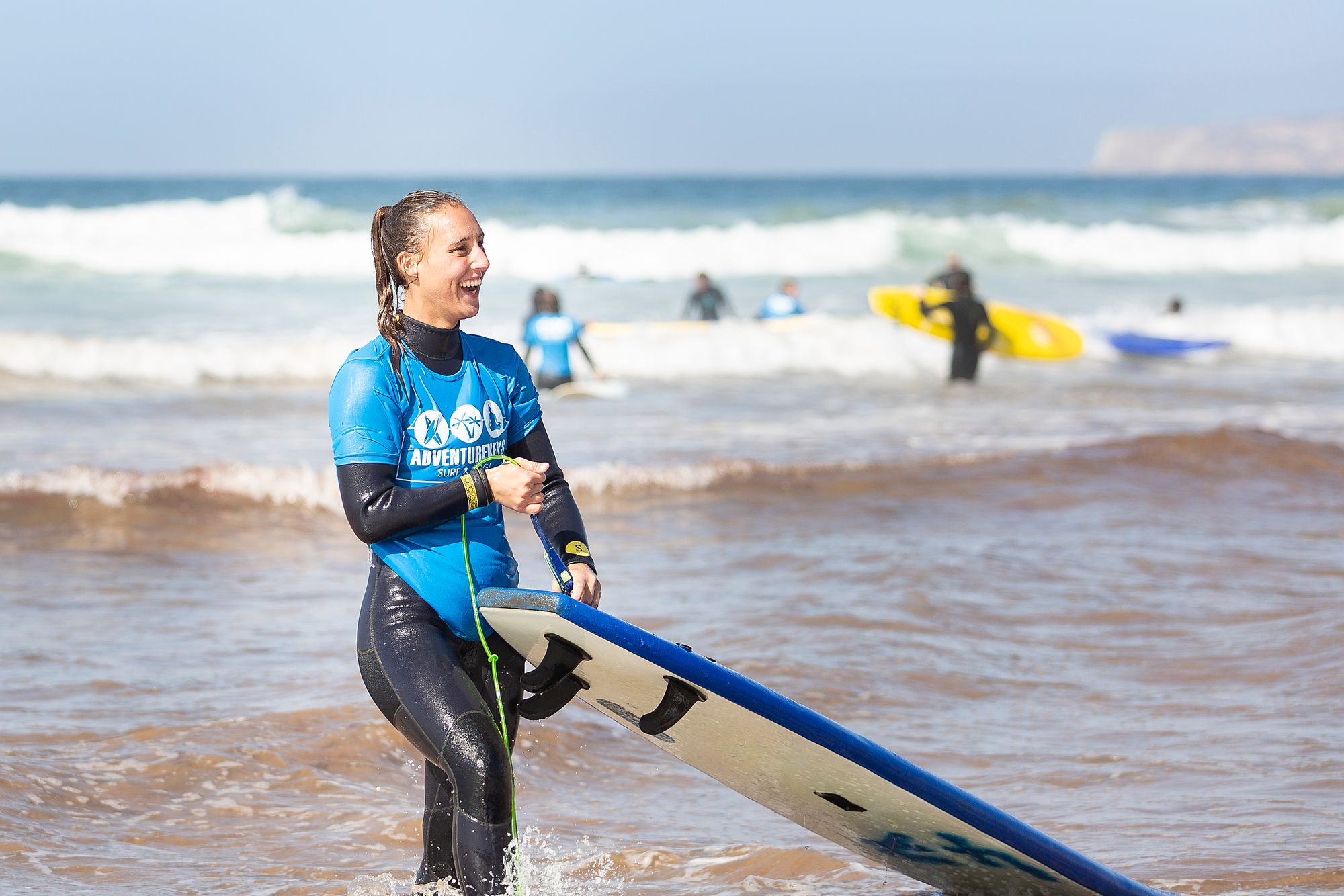 A woman surfer coming out of the water. 