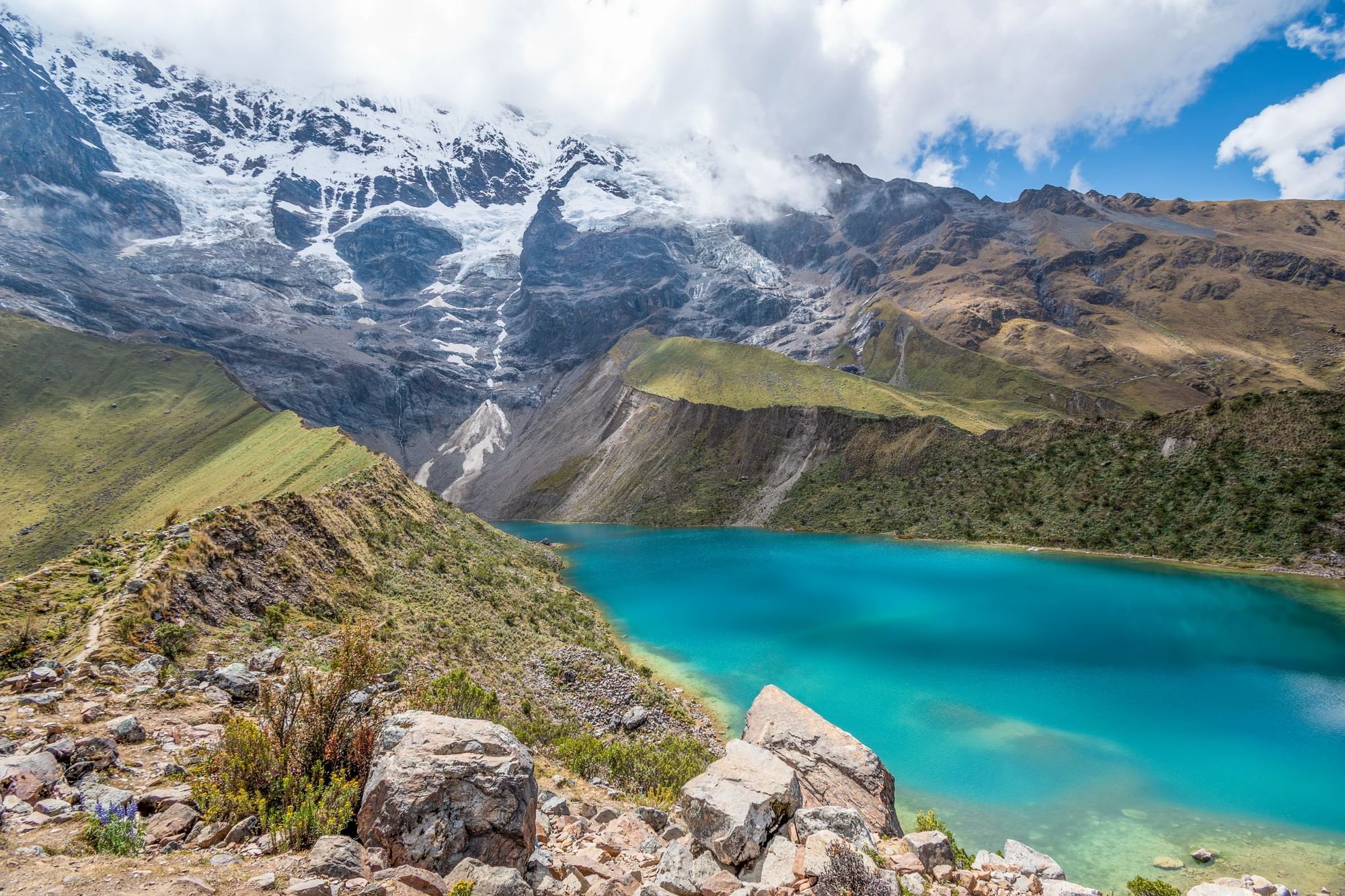 Vibrant blue water at Humantay Lake, which you visit on the Salkantay Trek. Photo: Getty.